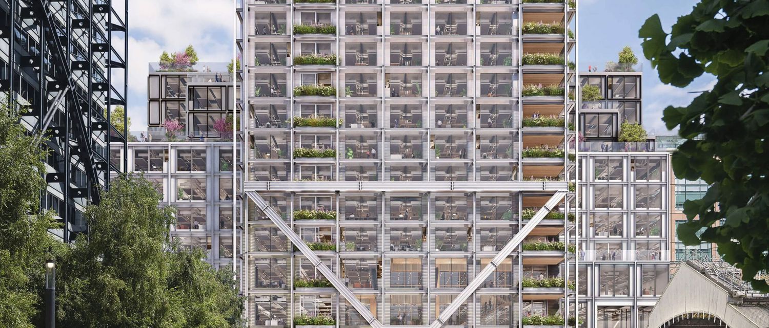 Modern high-rise building with white grid facade, green terraces, and industrial steel structure surrounded by urban trees.