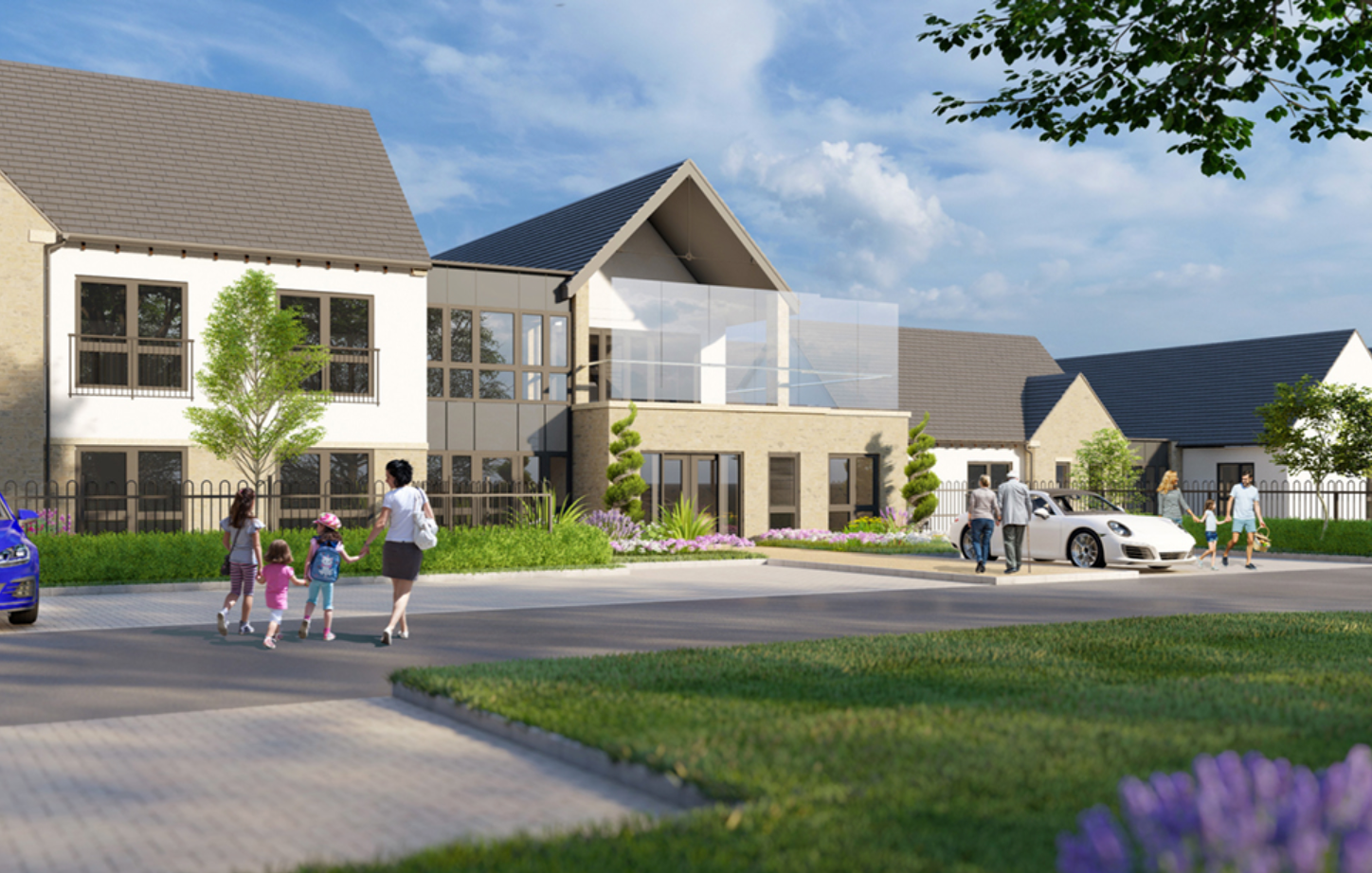 Modern residential development with contemporary homes, landscaped gardens, and families walking along a paved pathway on a sunny day.