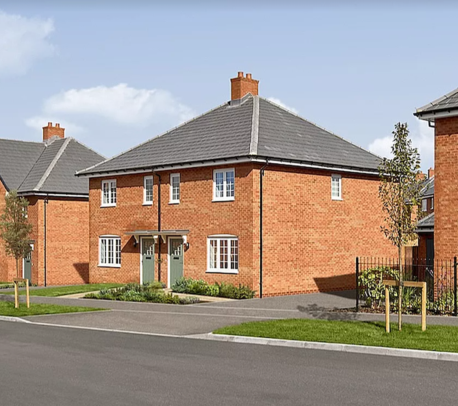 A panoramic view of modern red brick residential houses with grey roofs in a new suburban development.