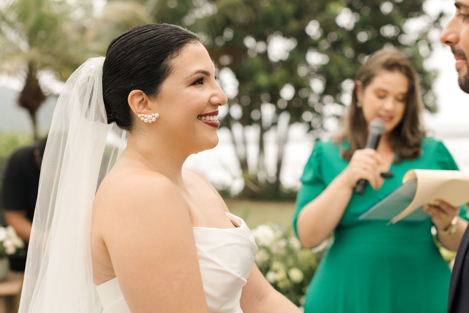 A candid moment during a wedding ceremony with attendees gathered outdoors.