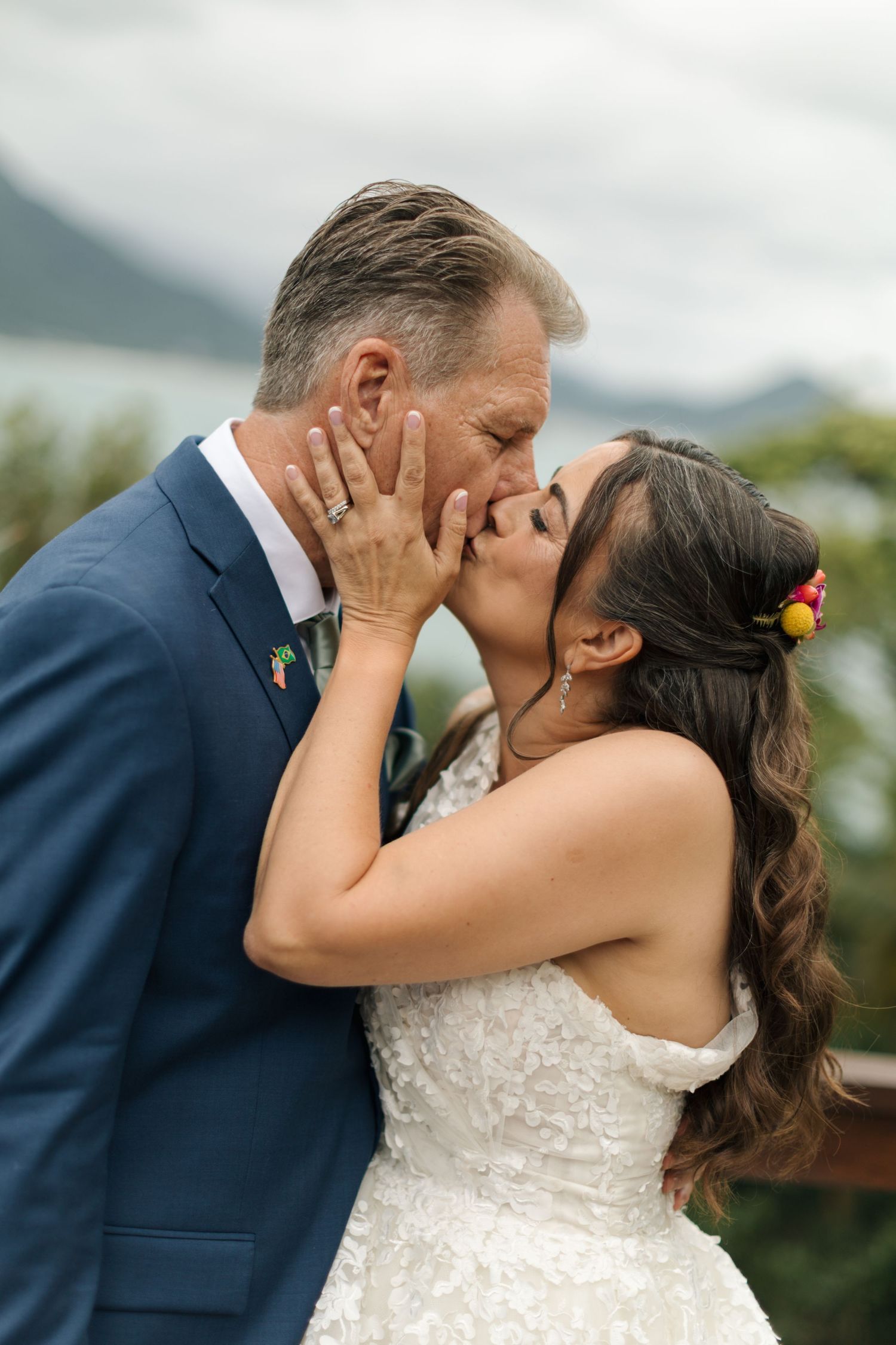 A romantic wedding moment captured against a mountainous tropical backdrop.