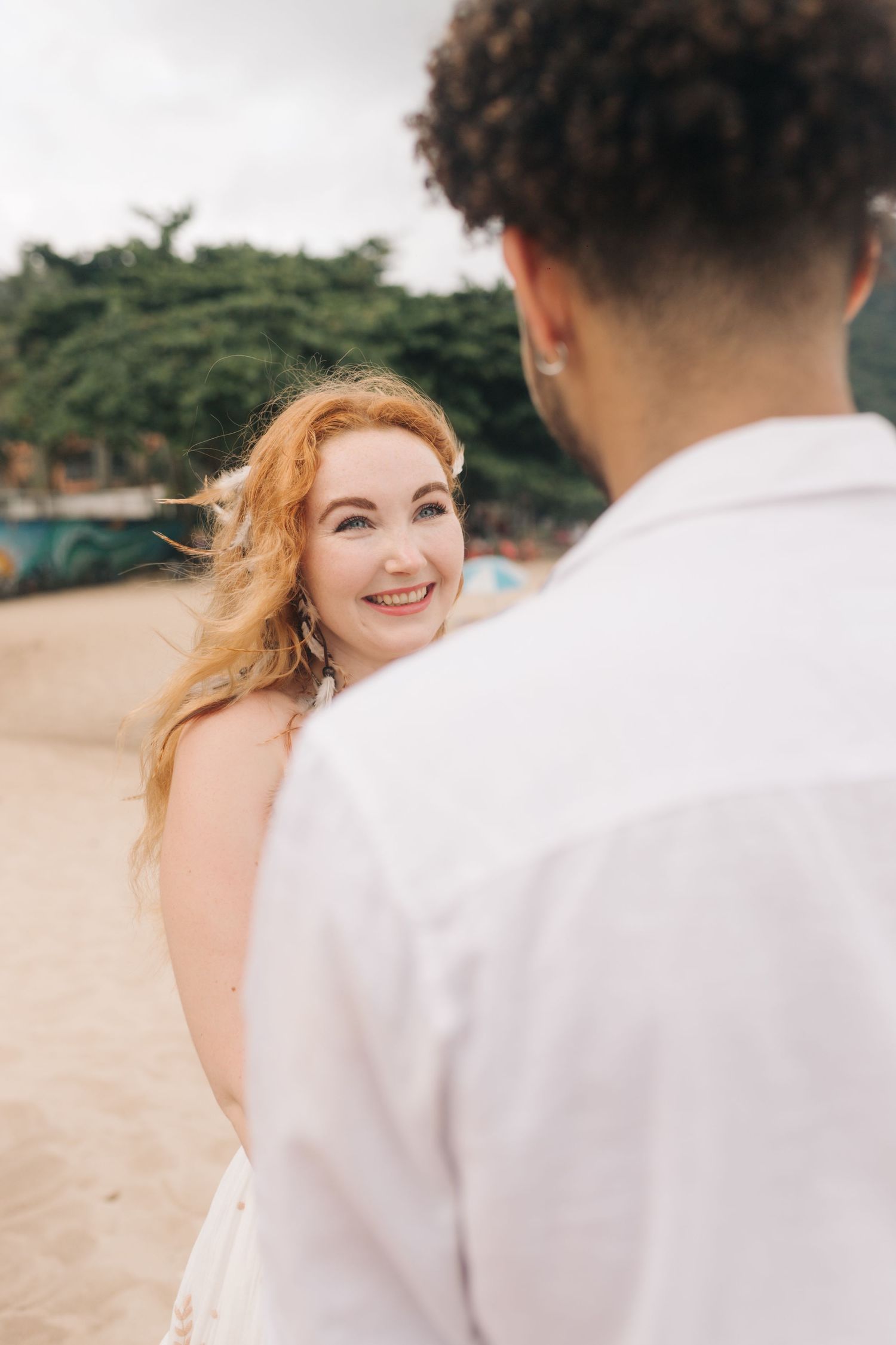 Candid moment of joy between couple during their beach wedding.
