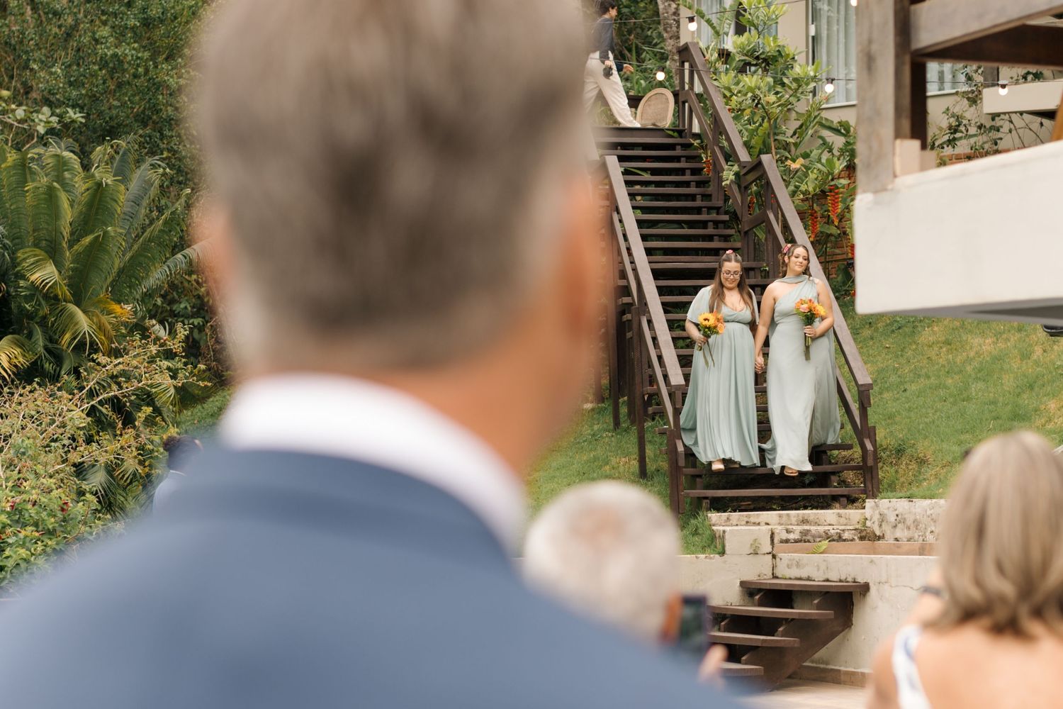 Outdoor wedding ceremony setup with natural lighting and garden backdrop.