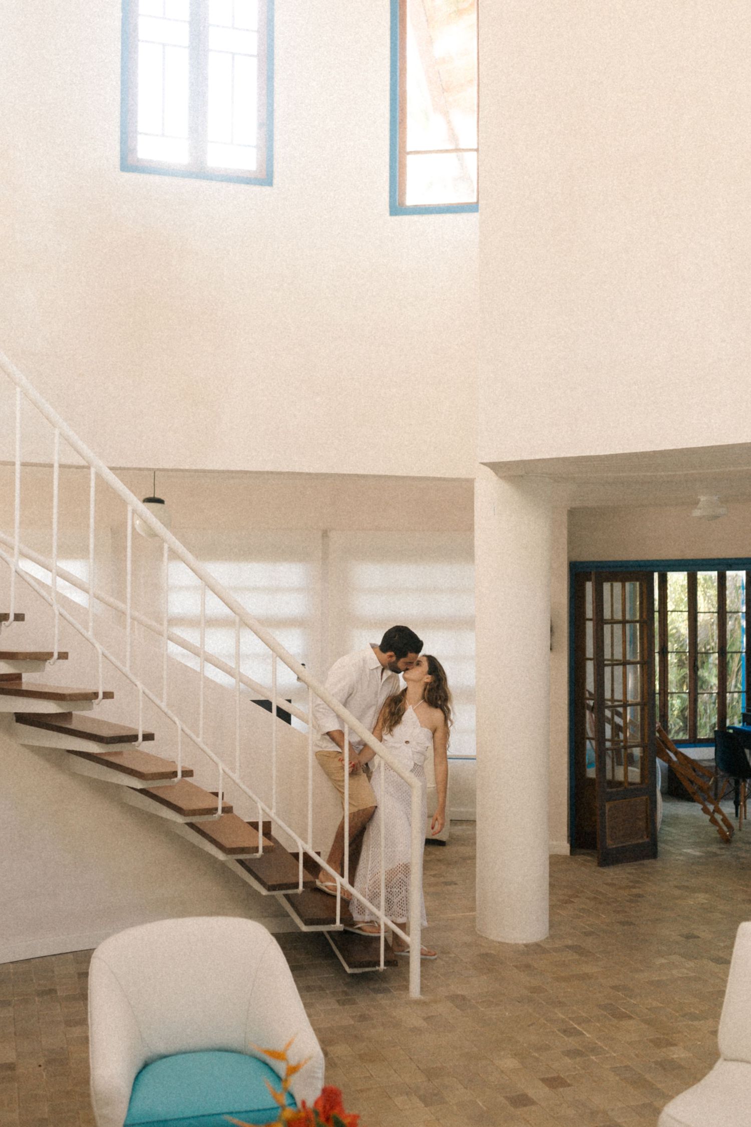 Couple standing on modern white staircase in minimalist interior with natural light.