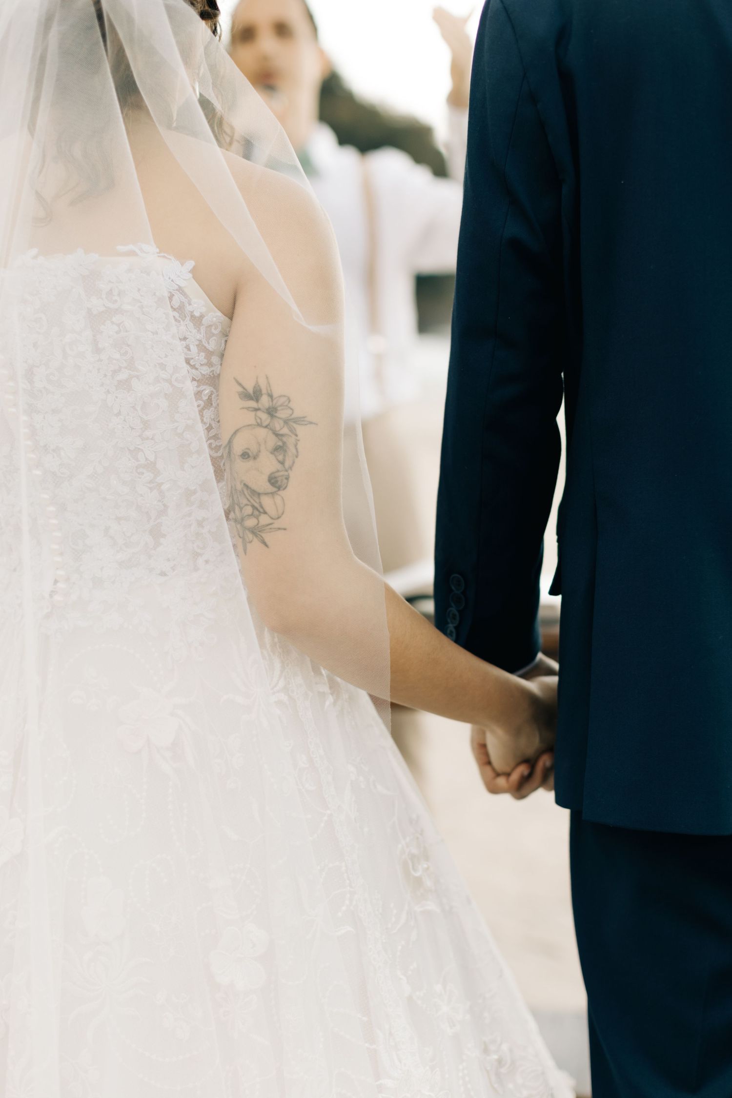 Wedding couple holding hands during a romantic beach ceremony.