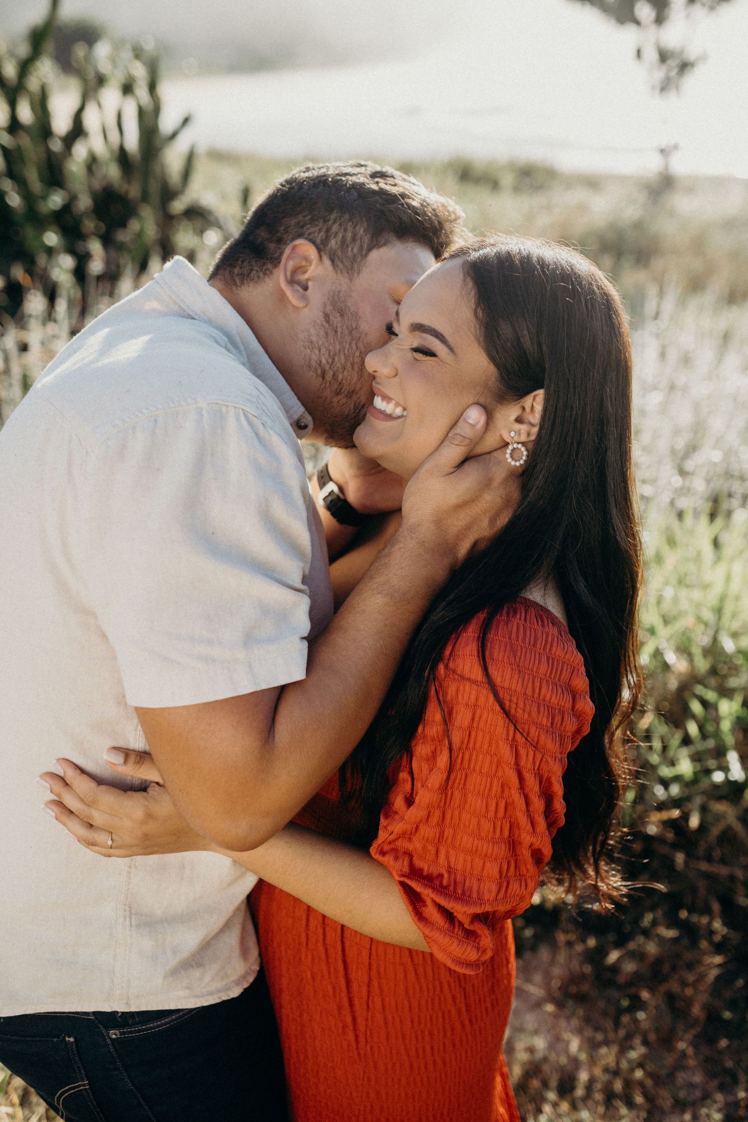 Romantic embrace captured in beautiful mountain setting during sunset photoshoot.