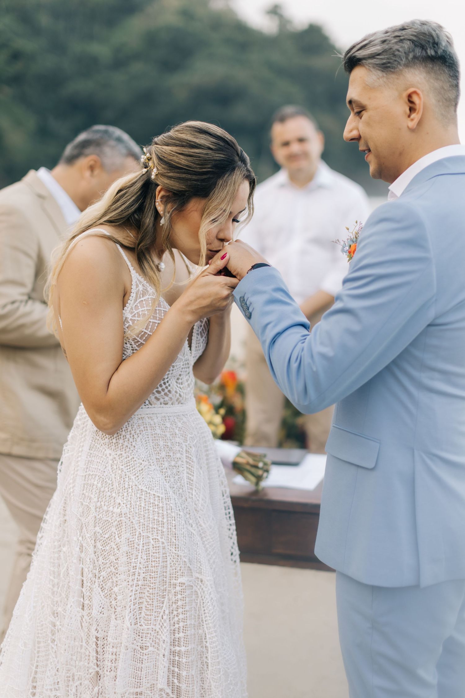 Emotional exchange during beach wedding ceremony with couple sharing intimate moment.