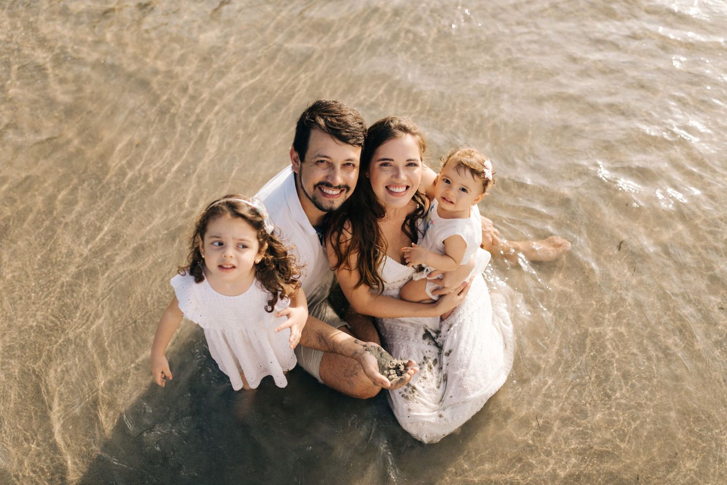 Happy family enjoying water play at scenic beach location.