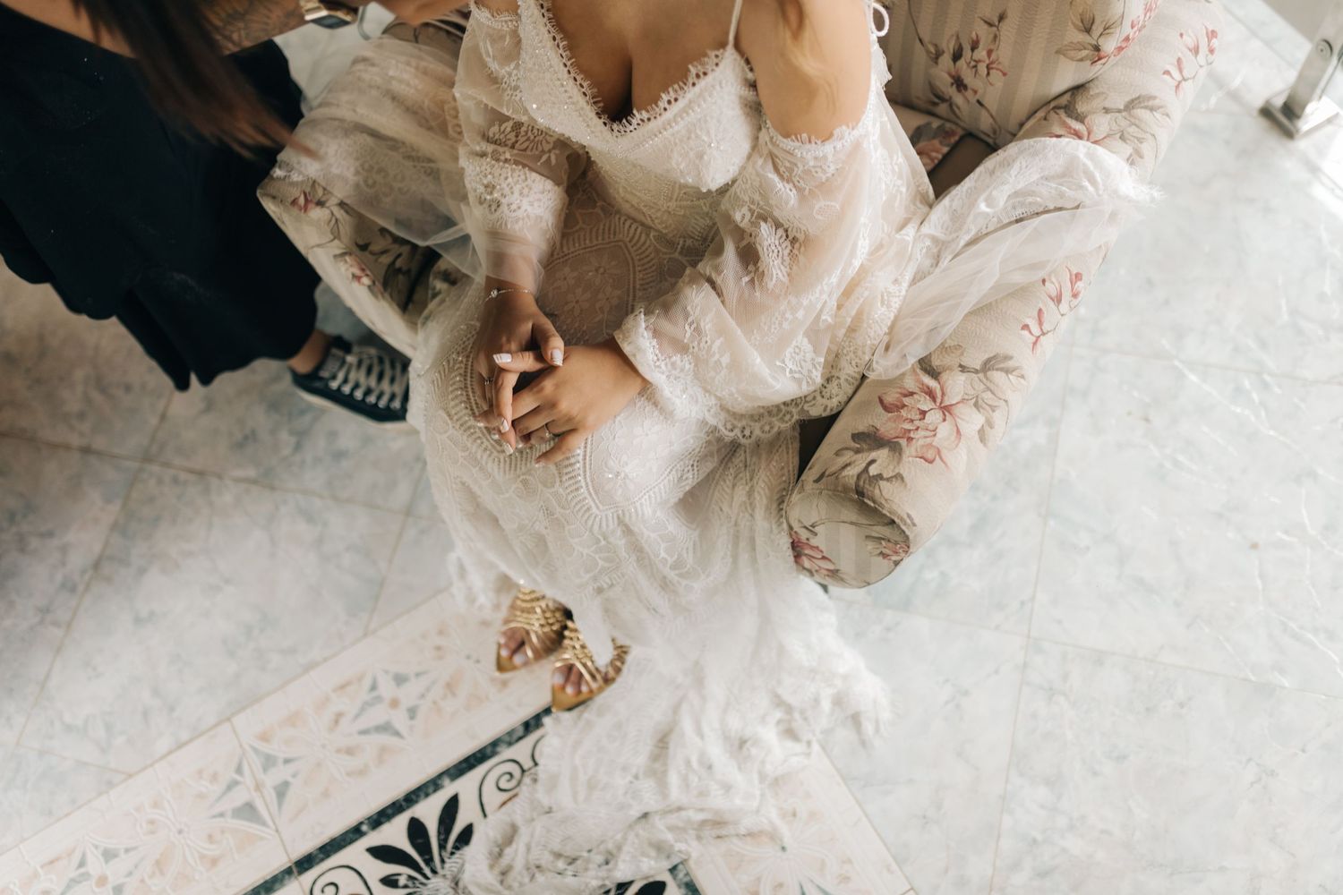 Detail shot of wedding dress and shoes during bridal preparation.
