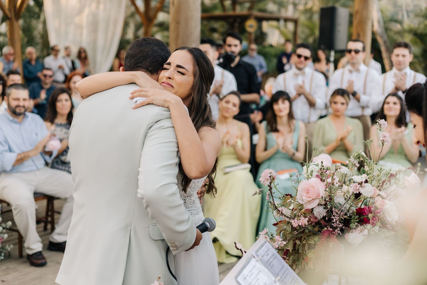 A heartfelt embrace shared during an intimate outdoor wedding ceremony.