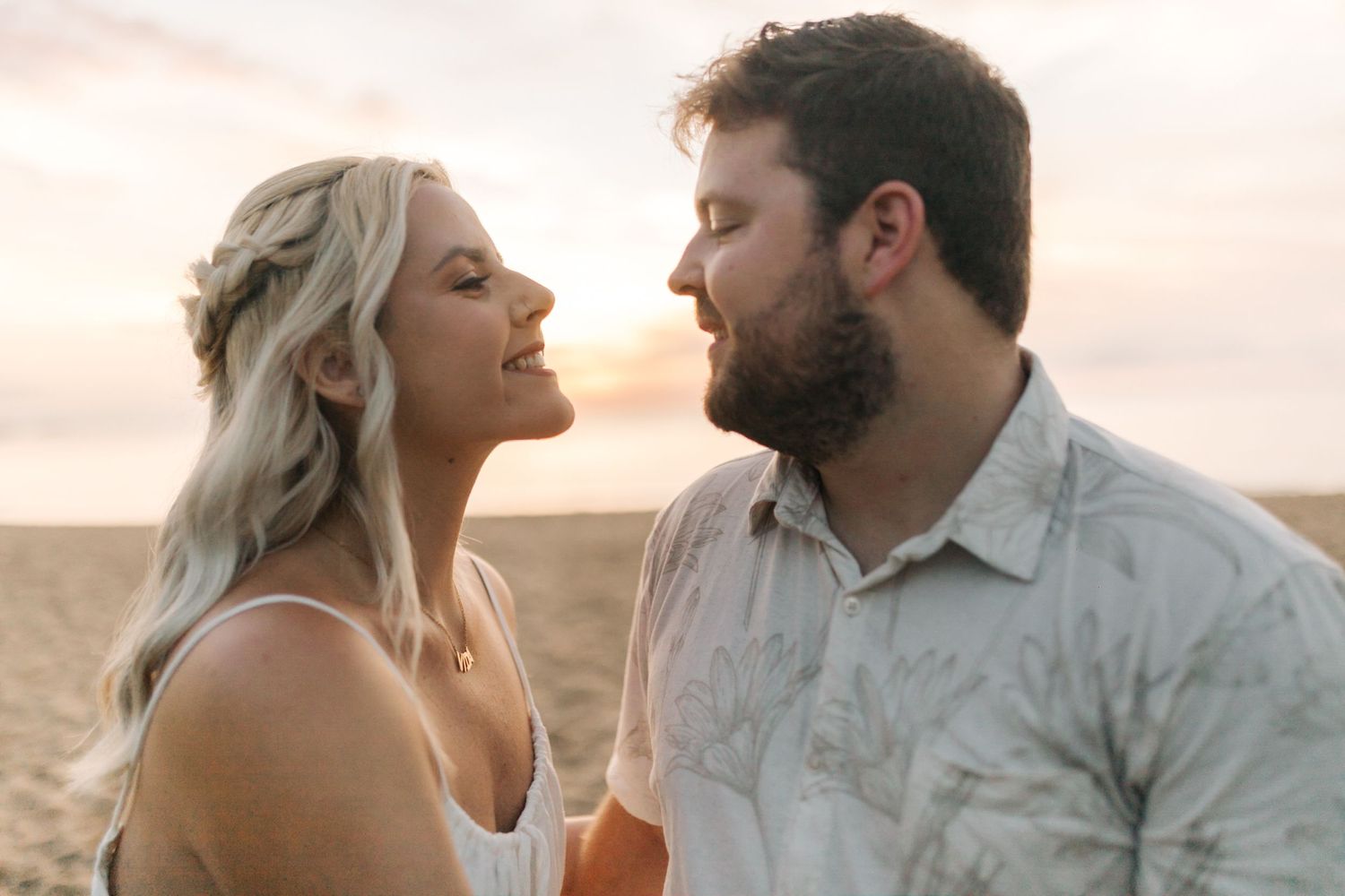 A romantic golden hour portrait of a couple against a scenic coastal backdrop.