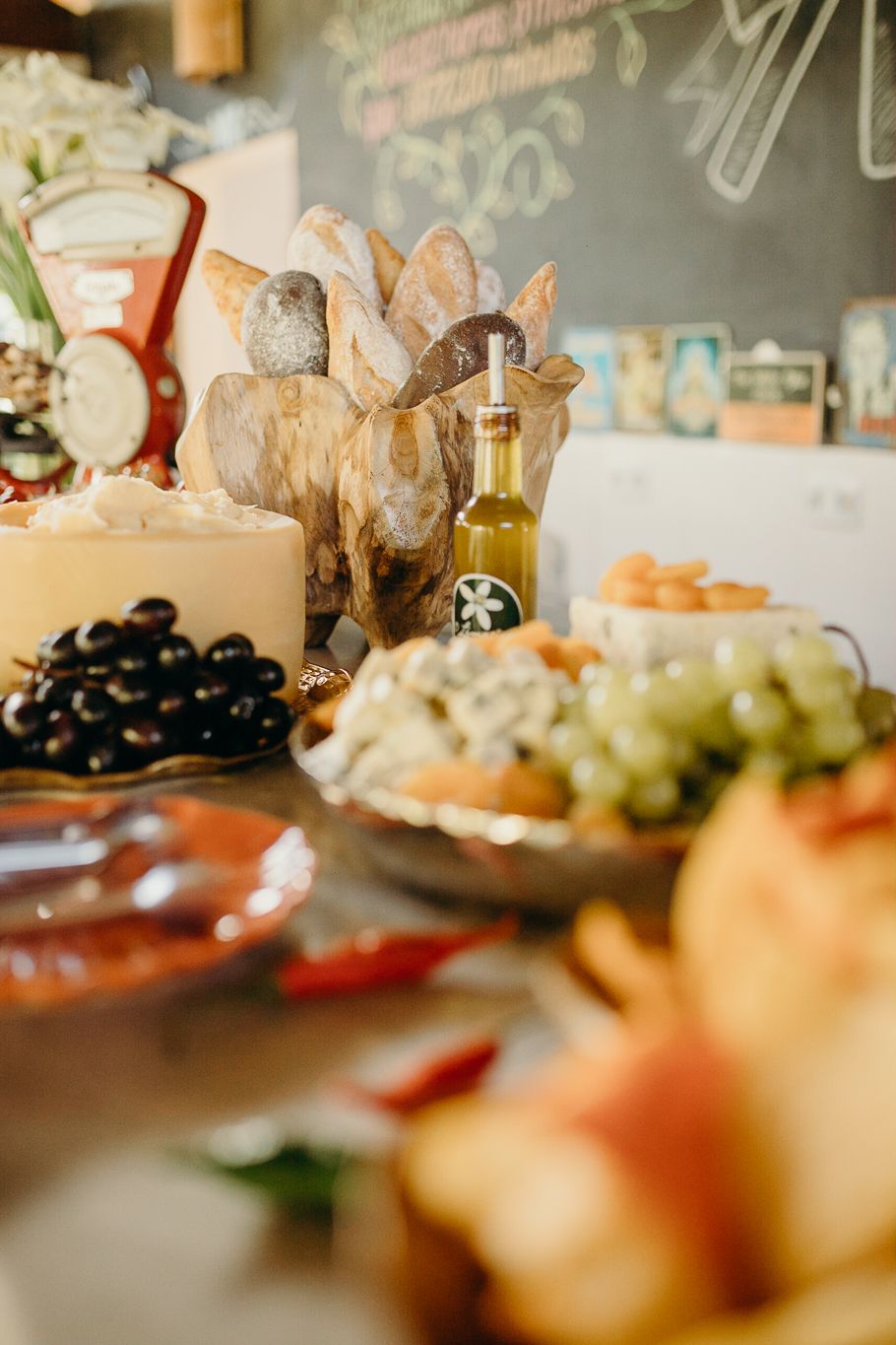 Blurred catering table with appetizers, olives, and wine bottles in soft focus.