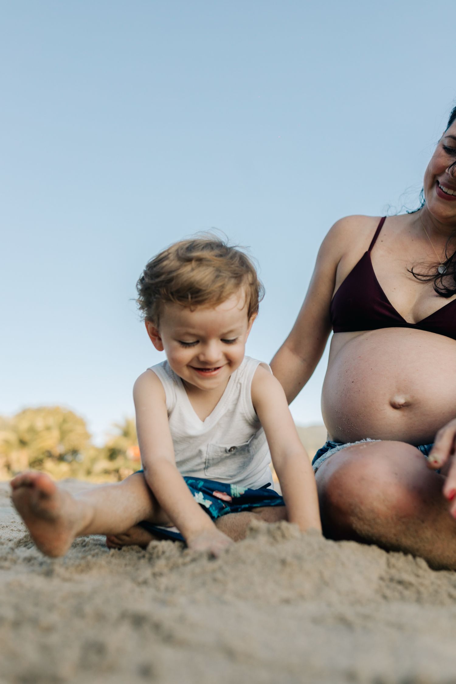Low angle shot of happy beachside play and sand exploration on a bright day.