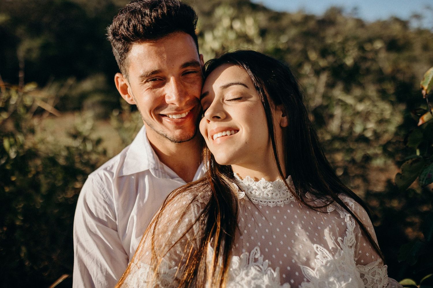 Joyful couple sharing intimate moment during outdoor wedding photoshoot.