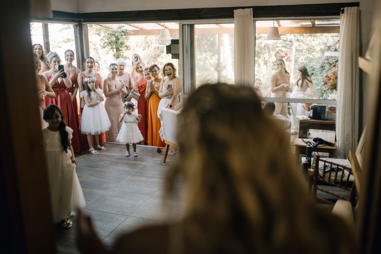 Wedding party guests gathering to welcome the bride in an indoor venue.
