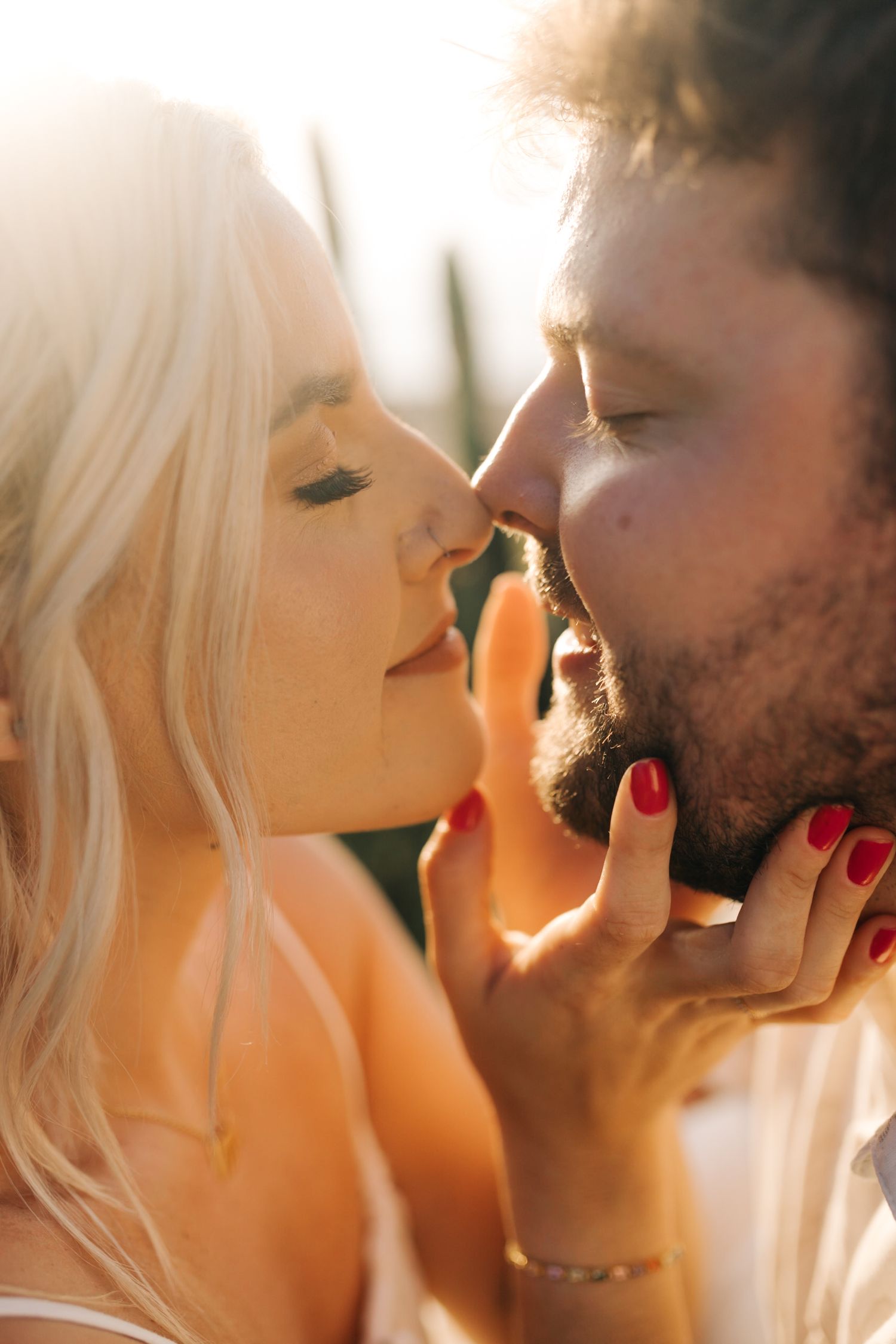 An intimate portrait of a couple sharing a tender moment in warm sunlight.