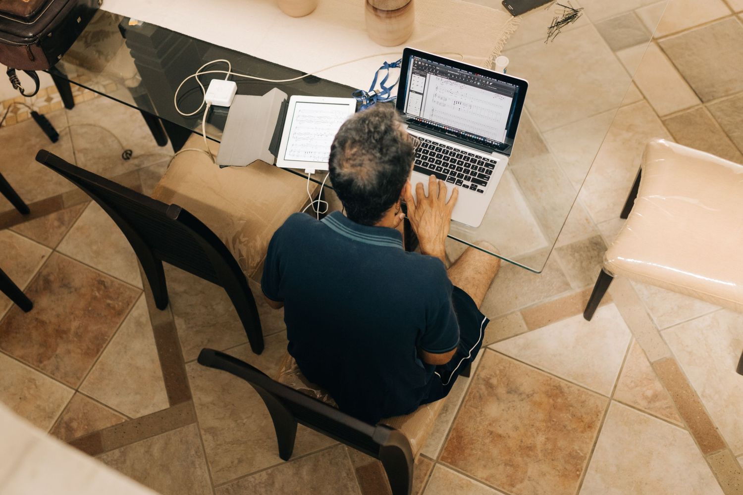 Overhead view of person working at desk with laptop and papers.