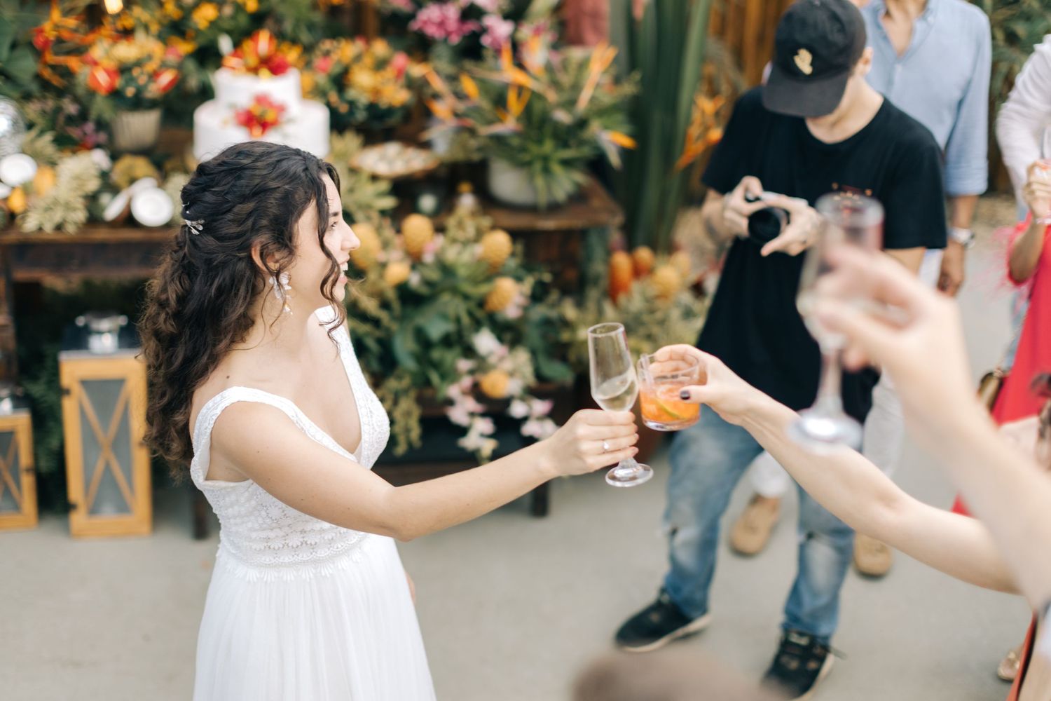 A wedding celebration with champagne toasts against a backdrop of tropical decorations and flowers.
