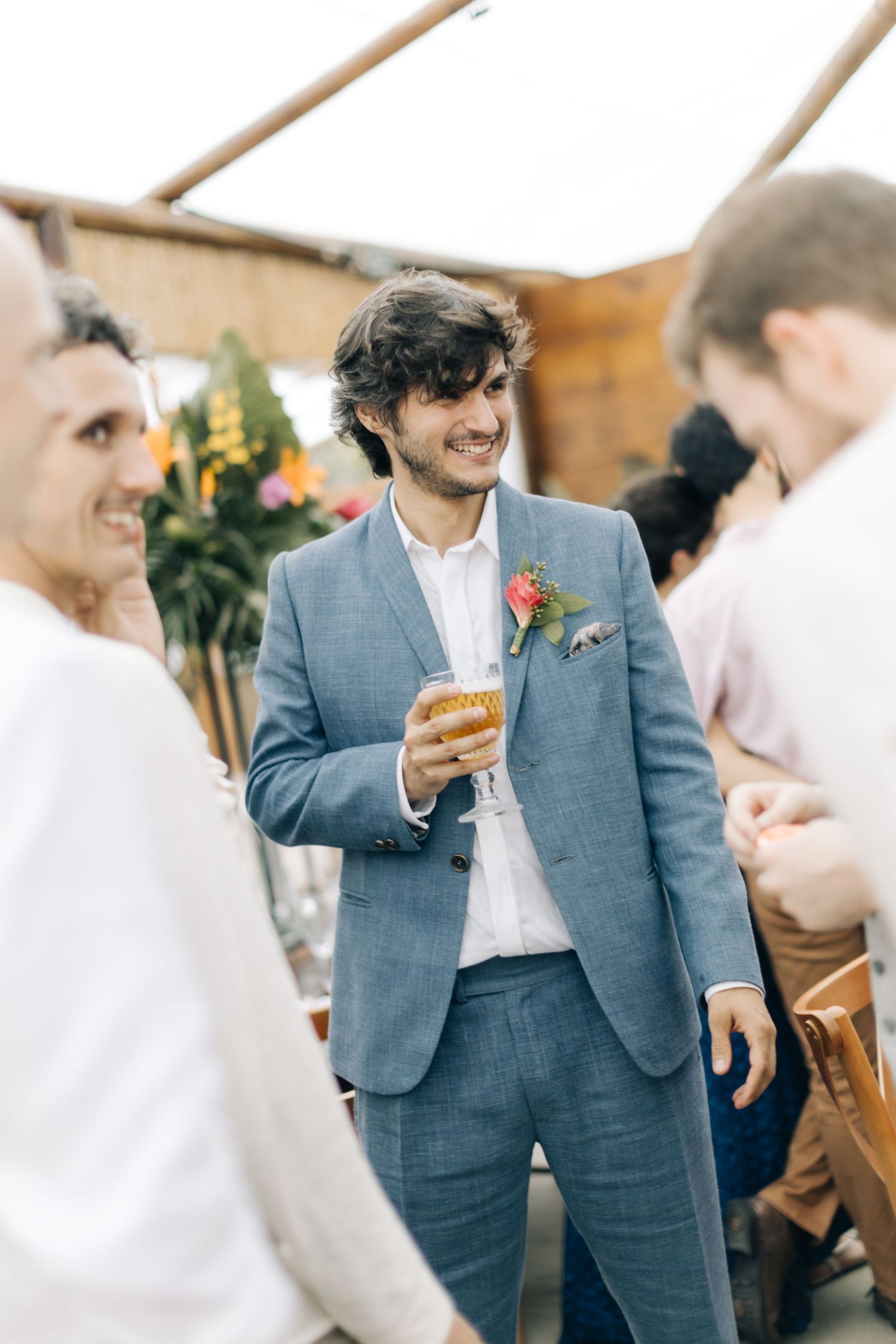 Wedding guests in formal attire mingle during a reception.
