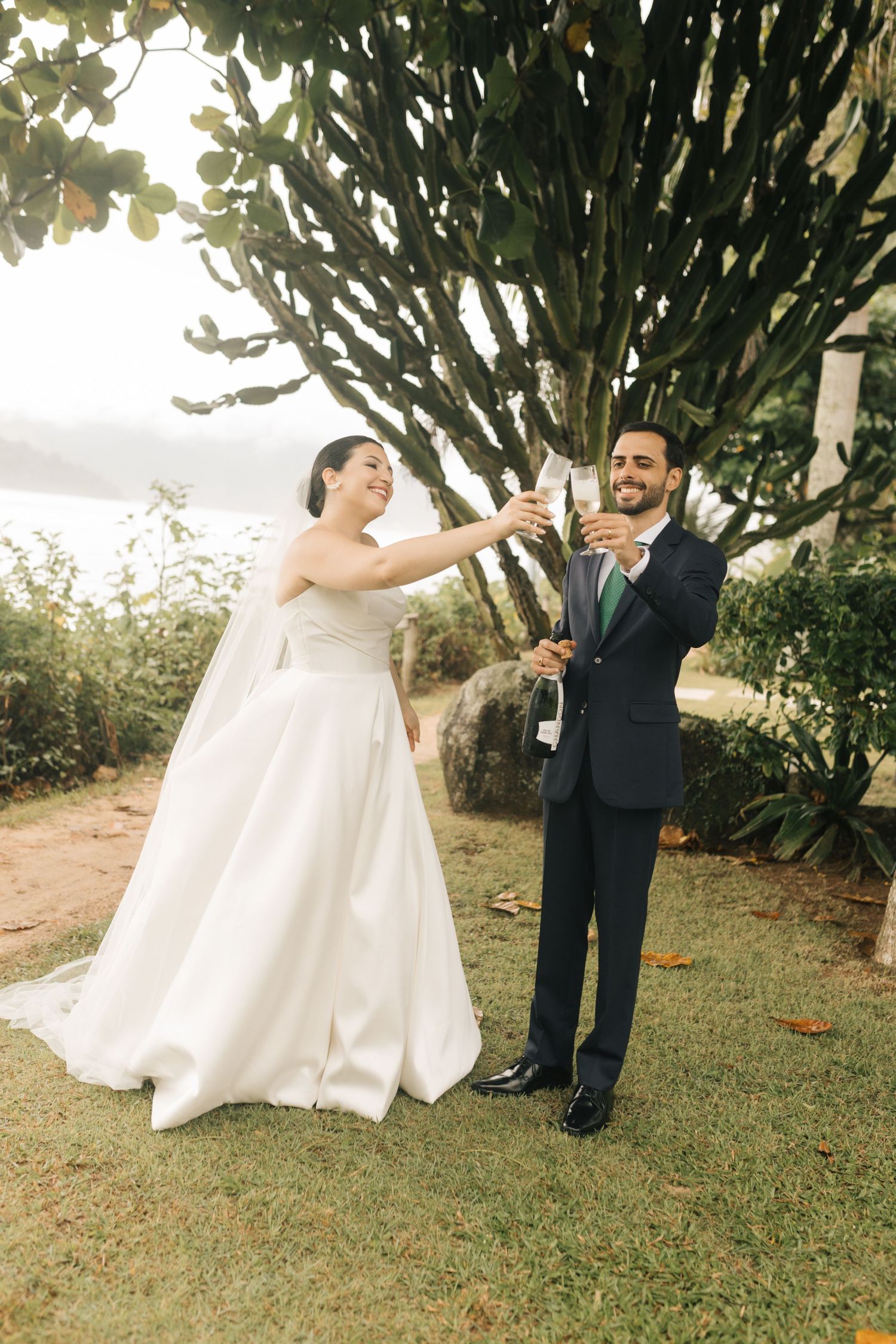 Bride and groom pop champagne during their outdoor wedding celebration.
