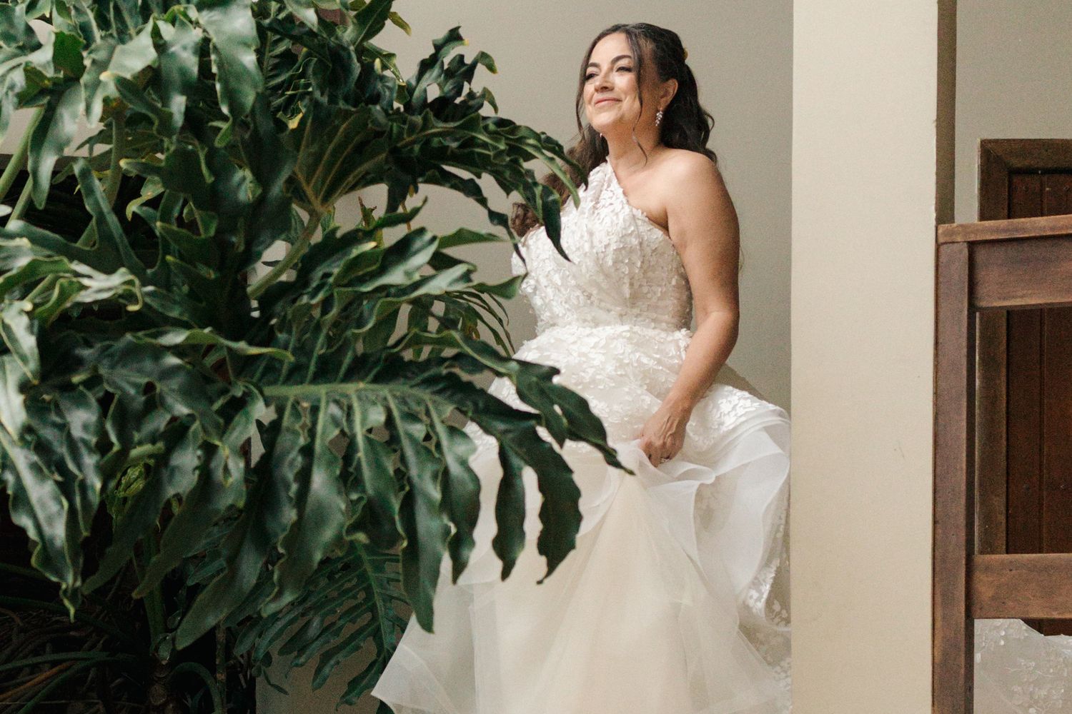 A bridal portrait session featuring tropical monstera leaves and natural lighting.