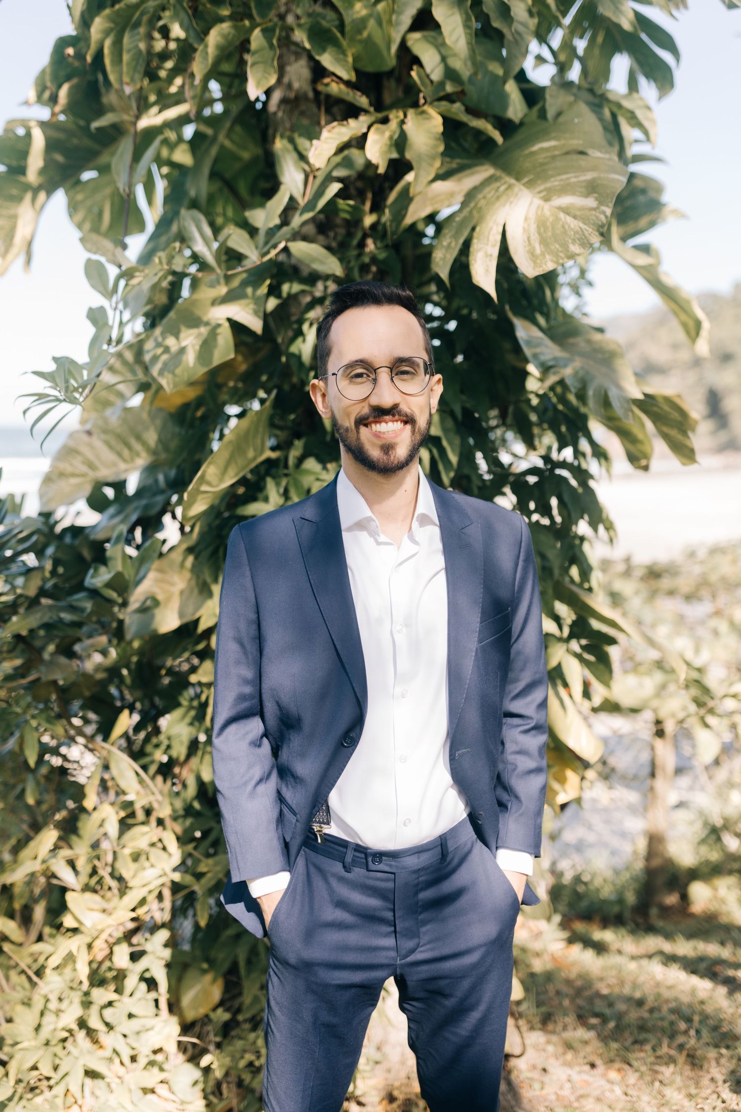 Professional portrait against tropical foliage backdrop in natural lighting.