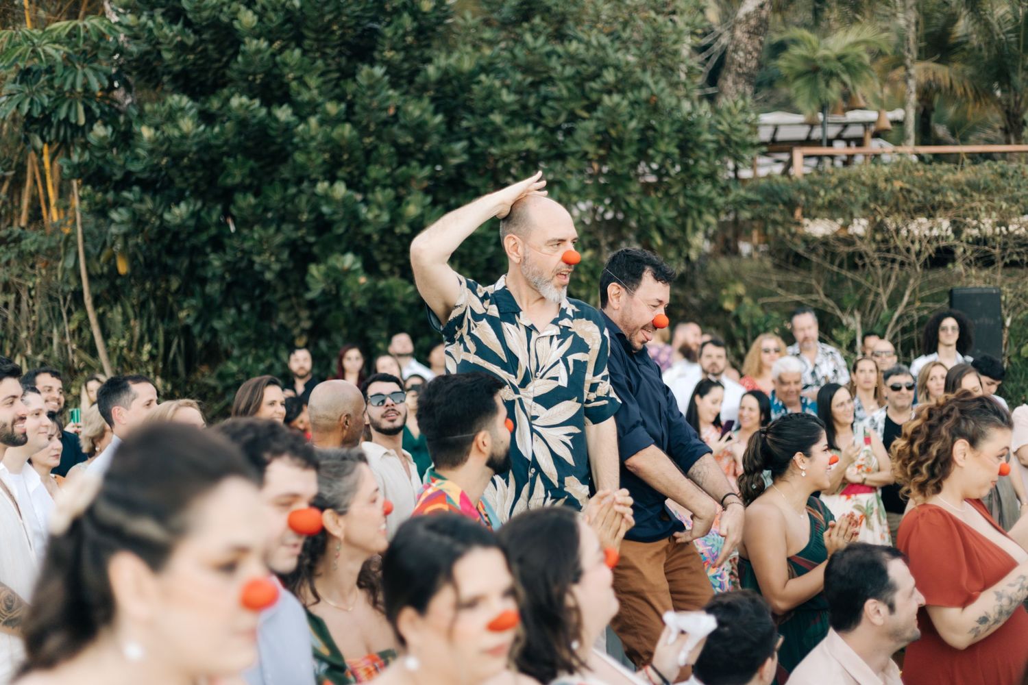 Wedding guests celebrating joyfully during outdoor reception party.