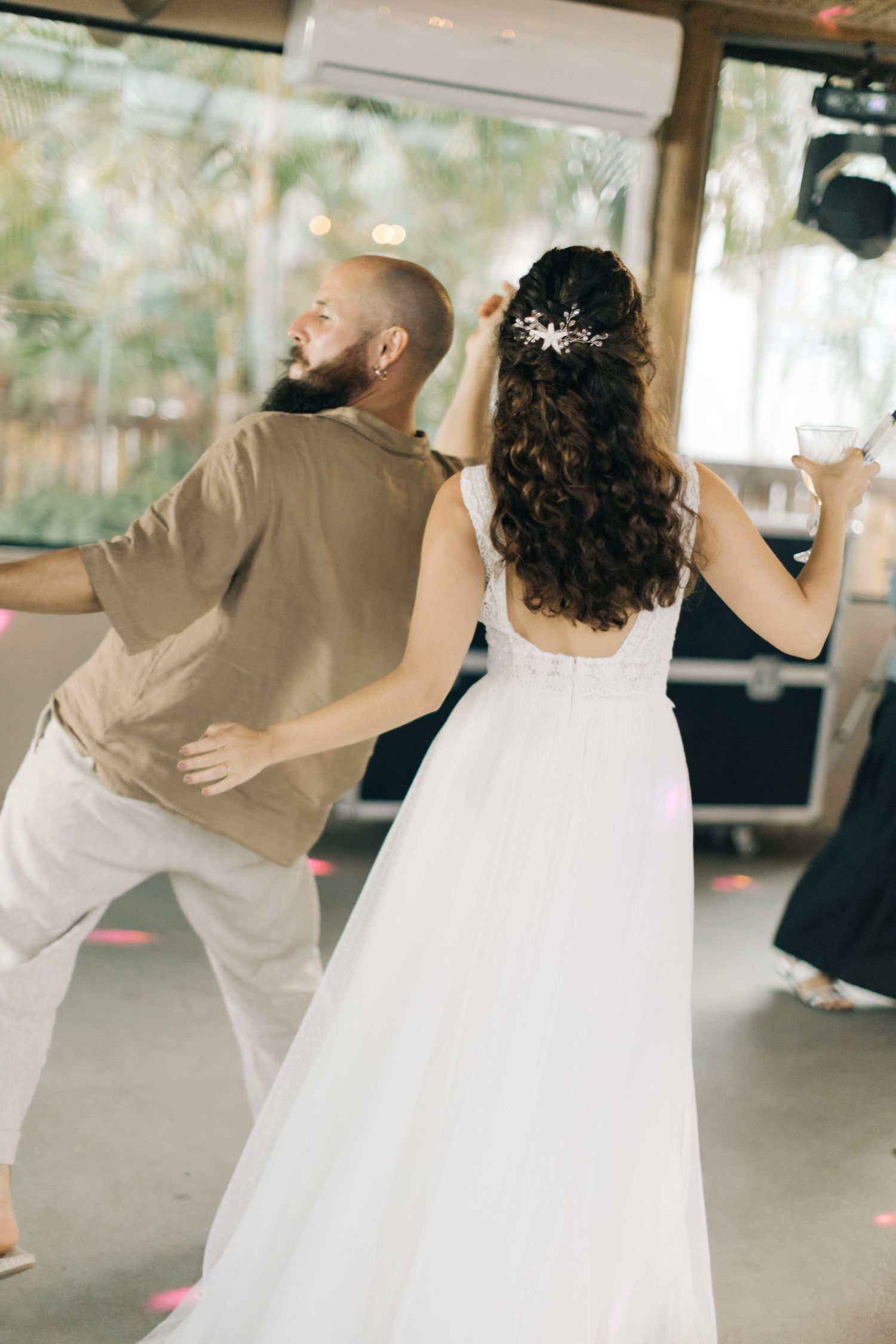 Wedding guests dancing and embracing during a reception celebration.