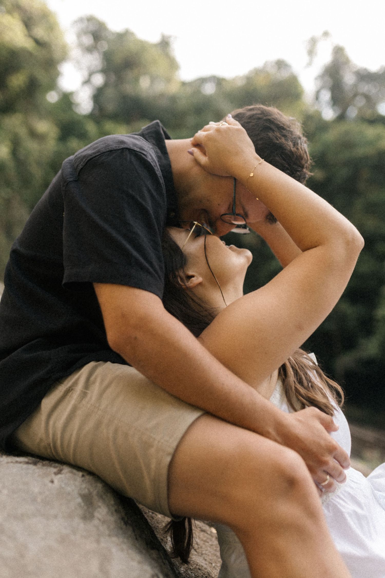 Natural candid moments captured of a couple sharing intimacy near a waterfall.