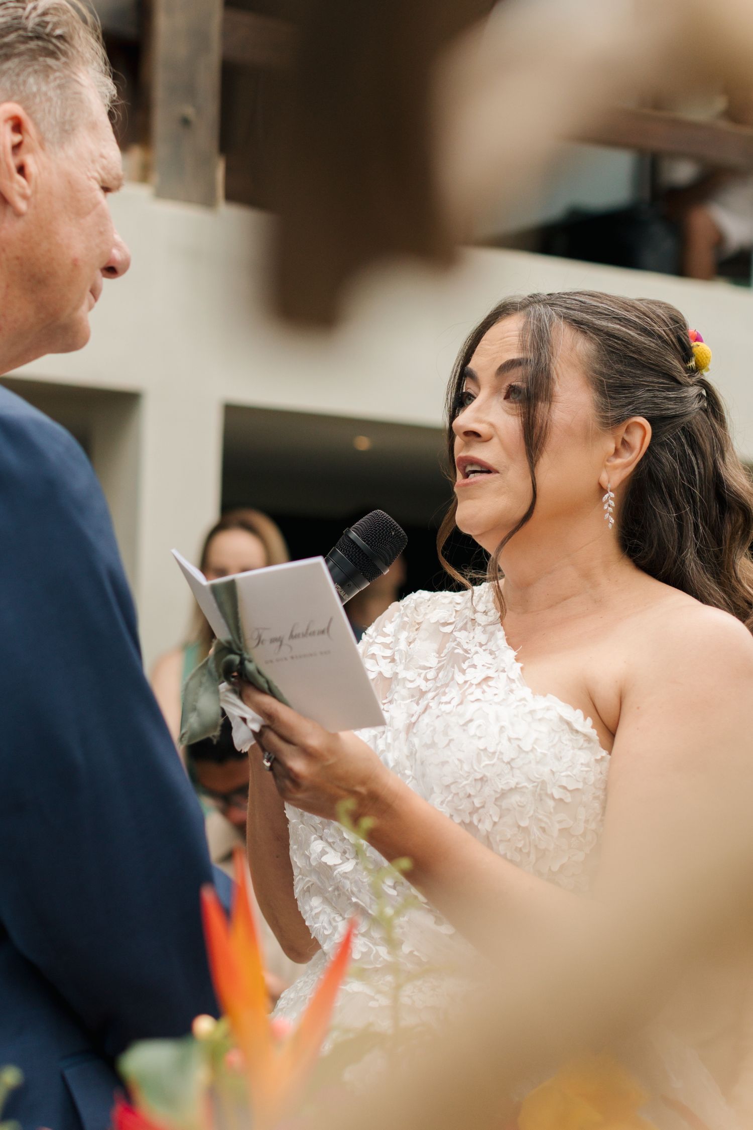 Close-up of wedding ceremony with white lace dress detail in focus.