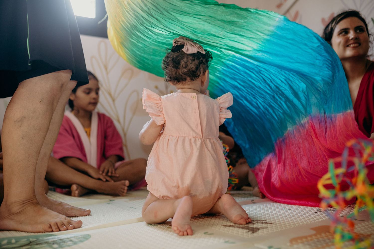 Vibrant blue and green fabric creates a canopy effect in an indoor play space.