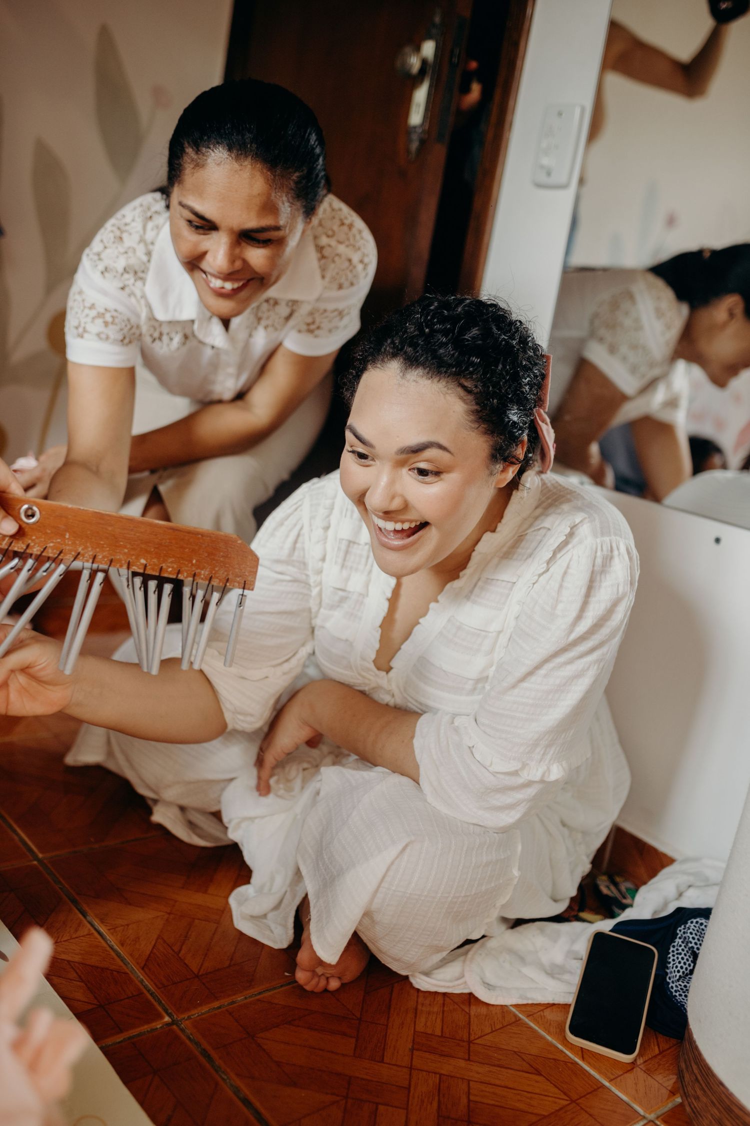 Music therapy participants sharing a joyful moment with chimes on wooden flooring.