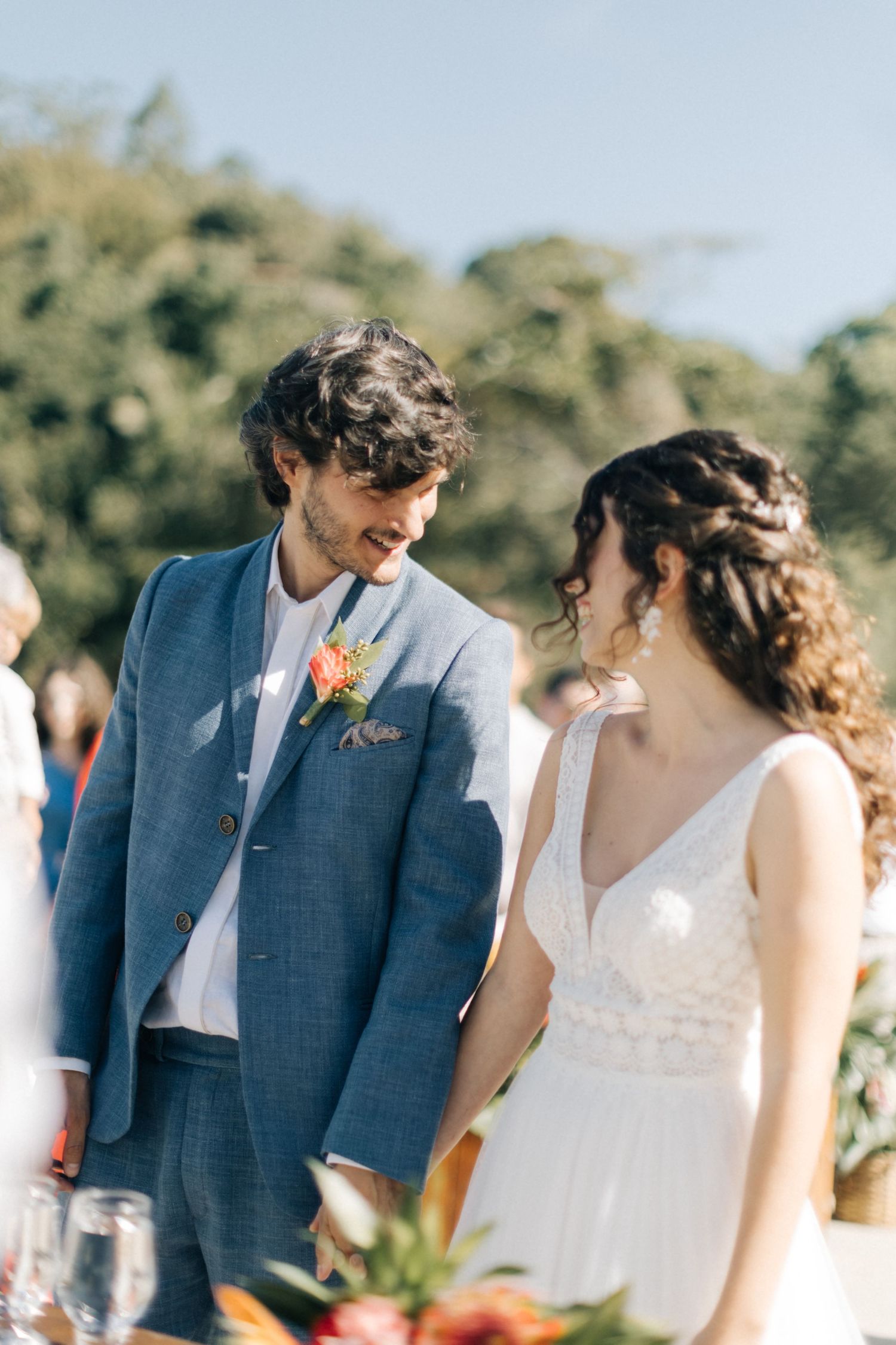Intimate wedding moment at outdoor ceremony with tropical floral decorations.