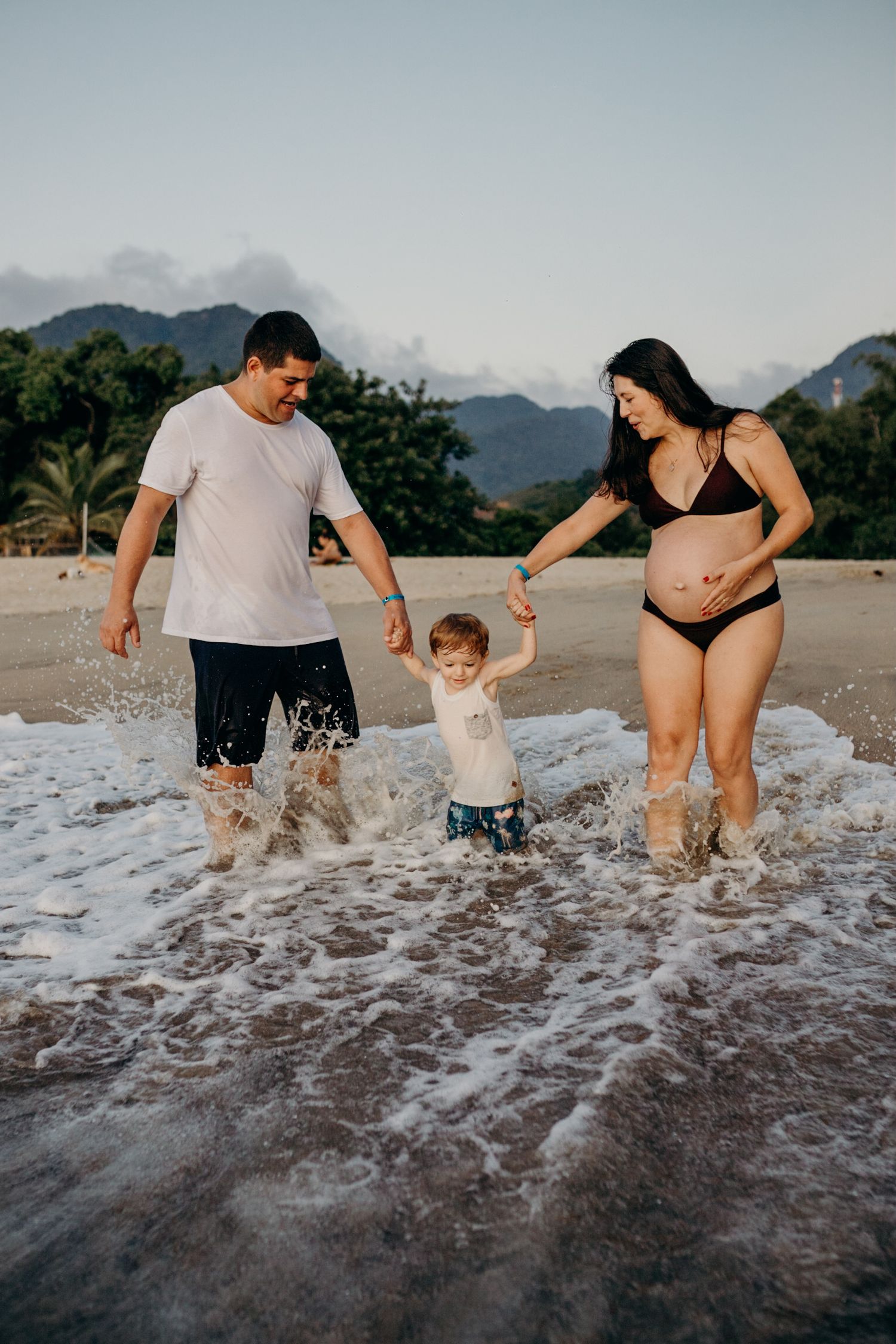 Family splashing and playing in the ocean waves at the beach.