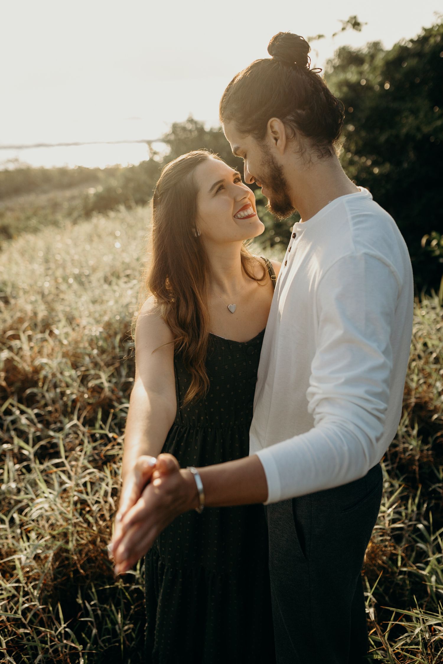 Couple shares intimate moment while dancing in golden afternoon light.