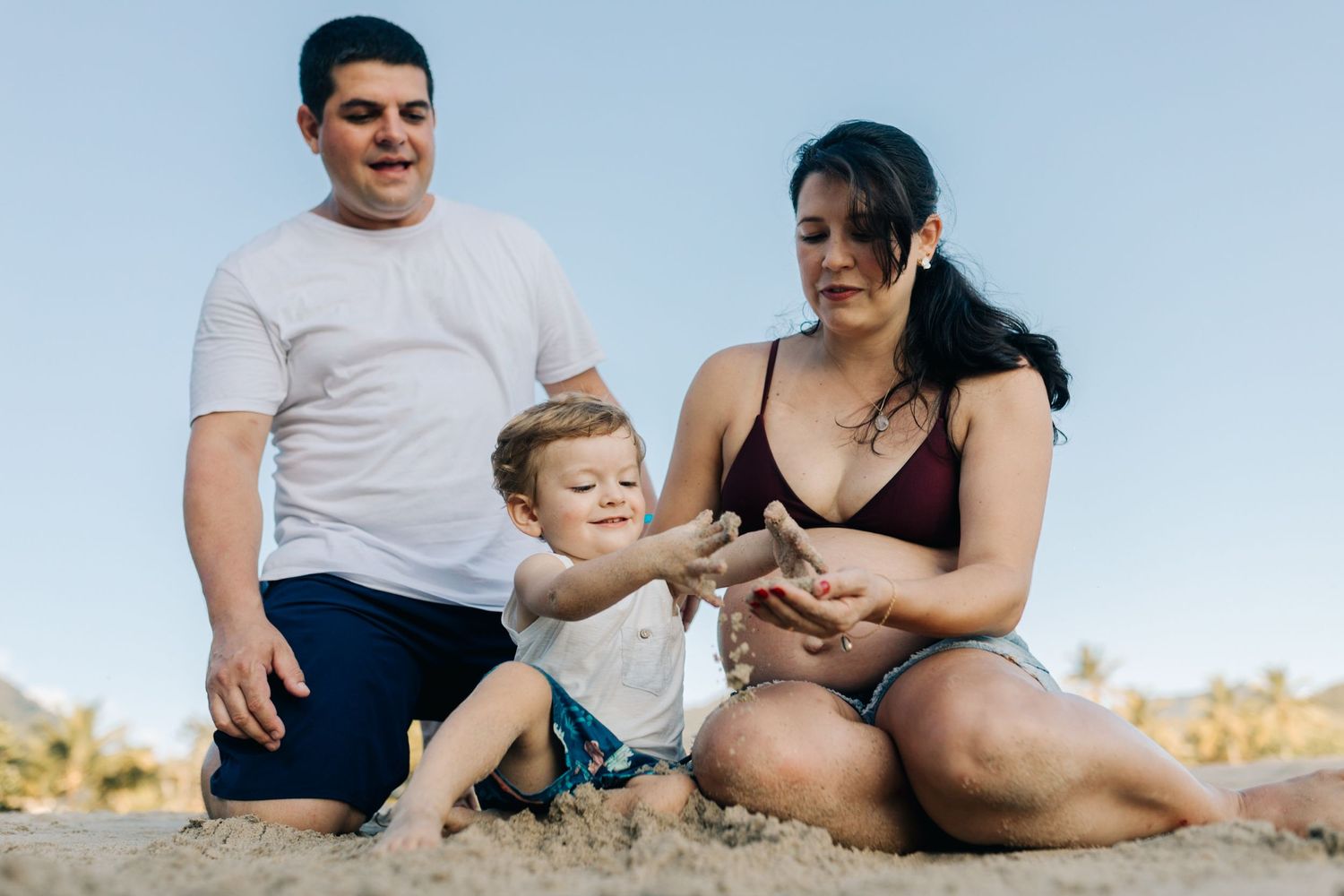 Candid moment of family togetherness and joy captured on a sunny beach.