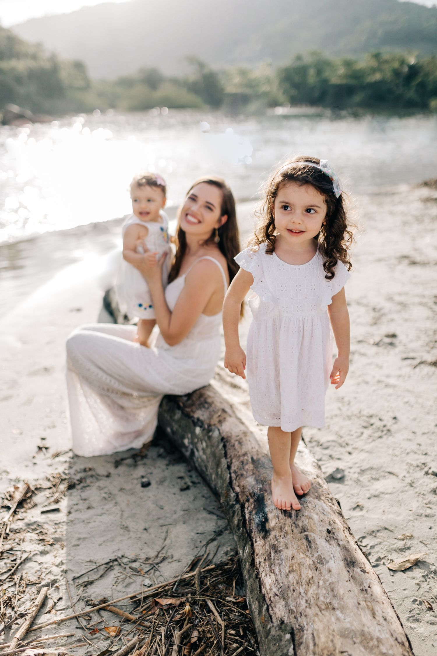 A beautiful sunset beach portrait with children on a washed-up log.