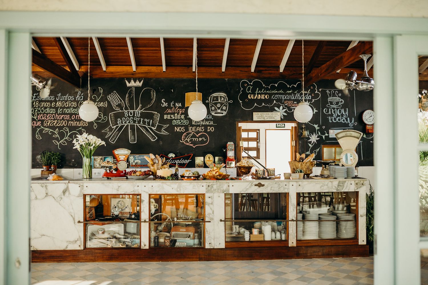 Restaurant interior with exposed wooden beams and chalkboard menu wall creating a rustic ambiance.