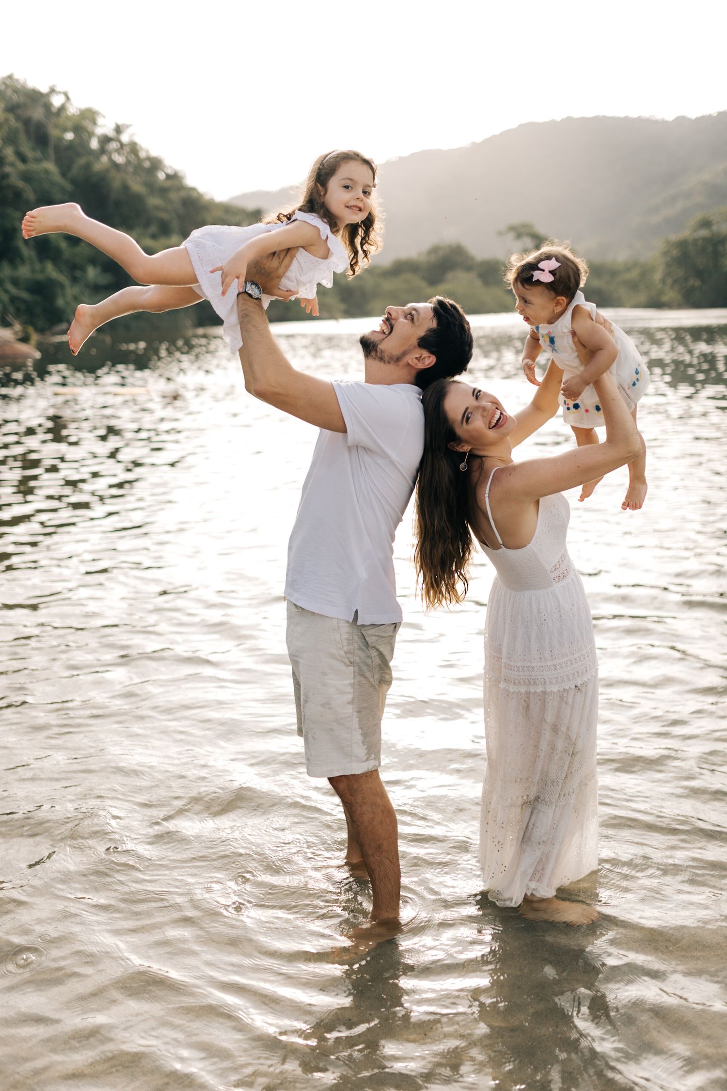 Joyful family moment captured while playing in ocean water during sunset.