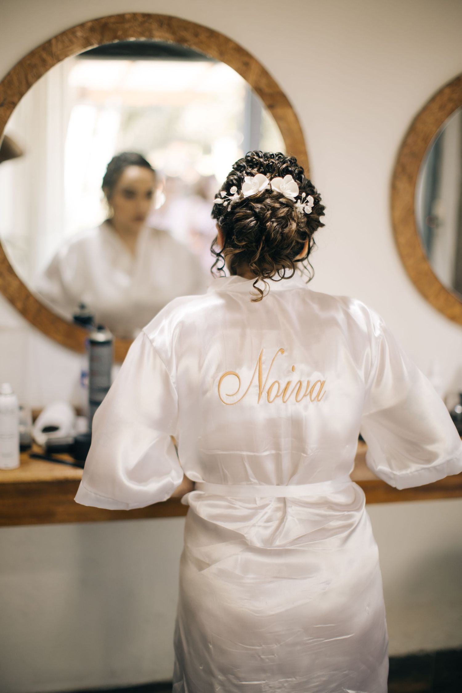 White satin robe with elegant embroidery detail captured in salon setting.