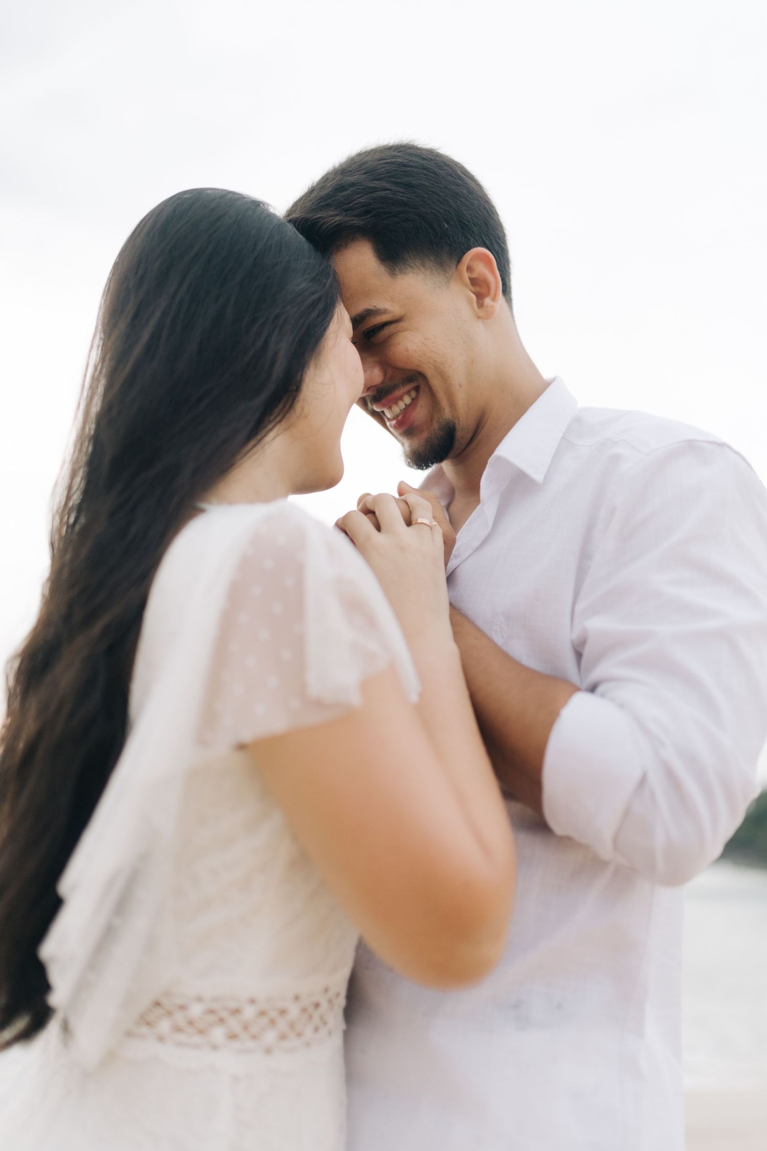 Intimate close-up of couple sharing tender moments in white outfits.