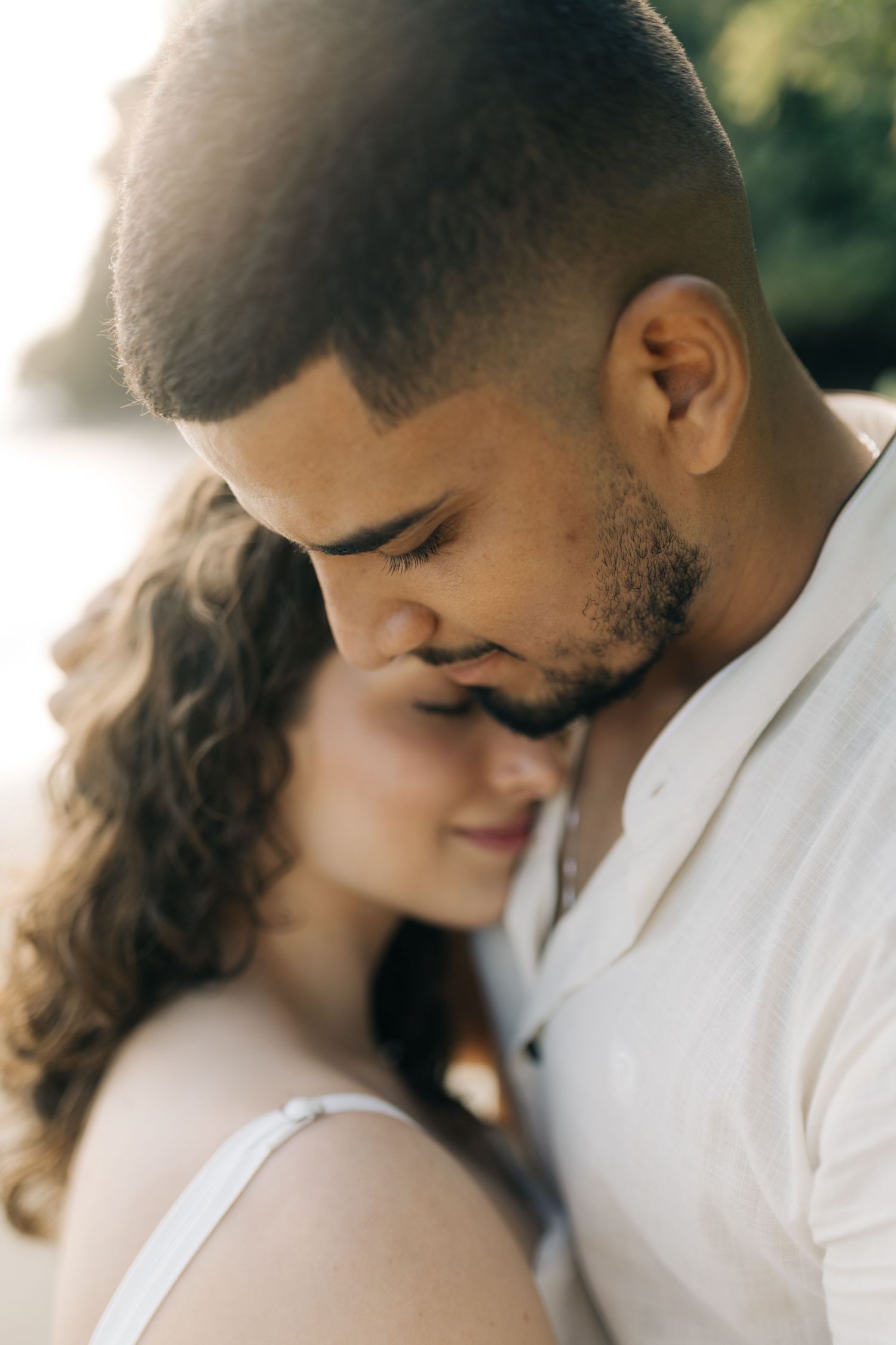 Close up of intimate couple's embrace during beach photo session.