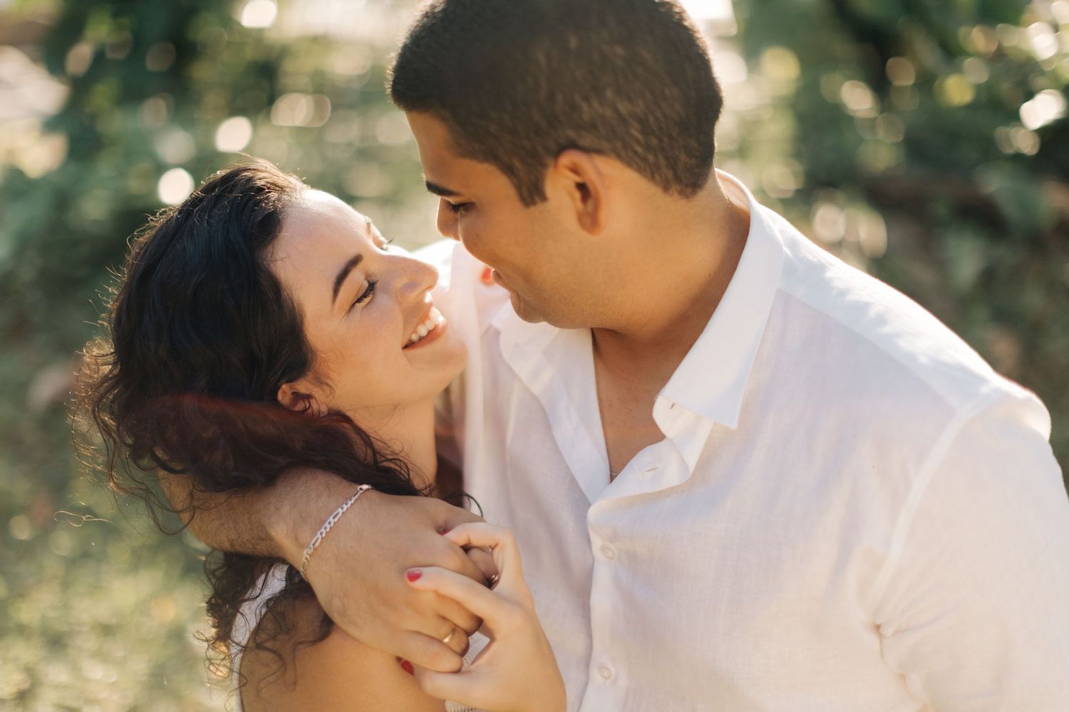 Joyful couple laughing together during outdoor portrait session.