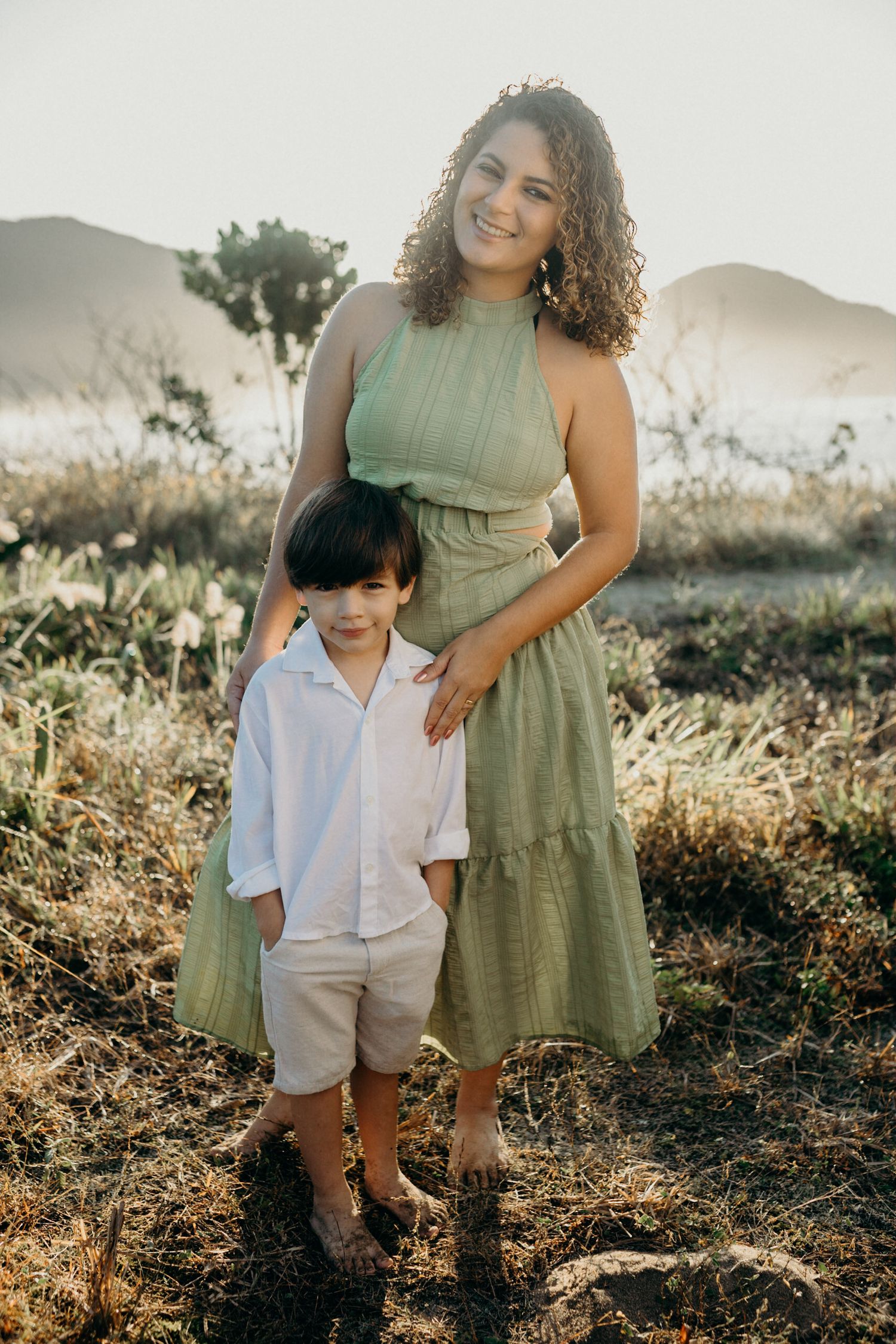 Portrait of two people enjoying a tender moment together in front of scenic hills at sunset.