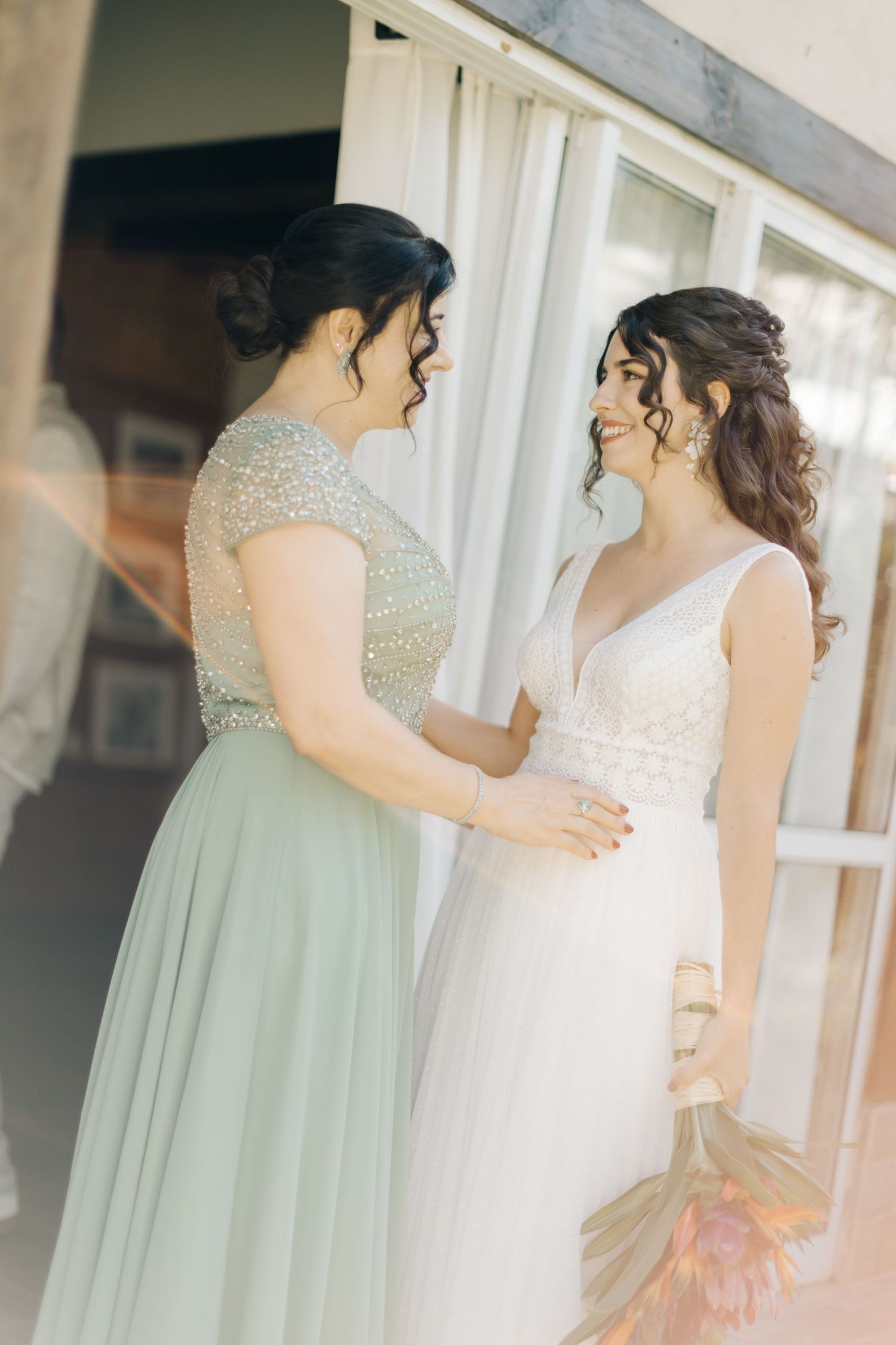Wedding party in mint green and white dresses gathered for photos.
