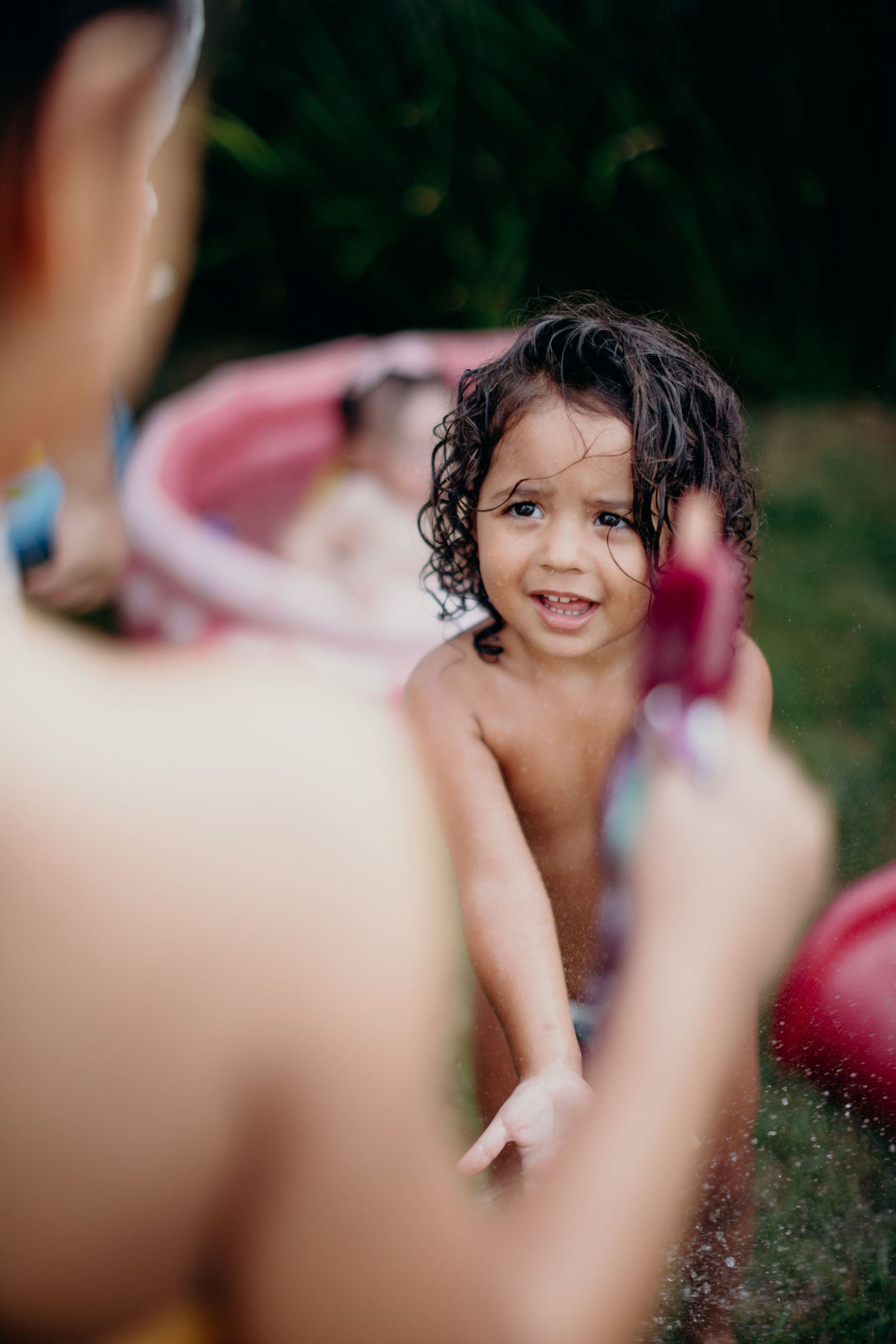 A joyful summer moment filled with water splashes and laughter in the backyard.