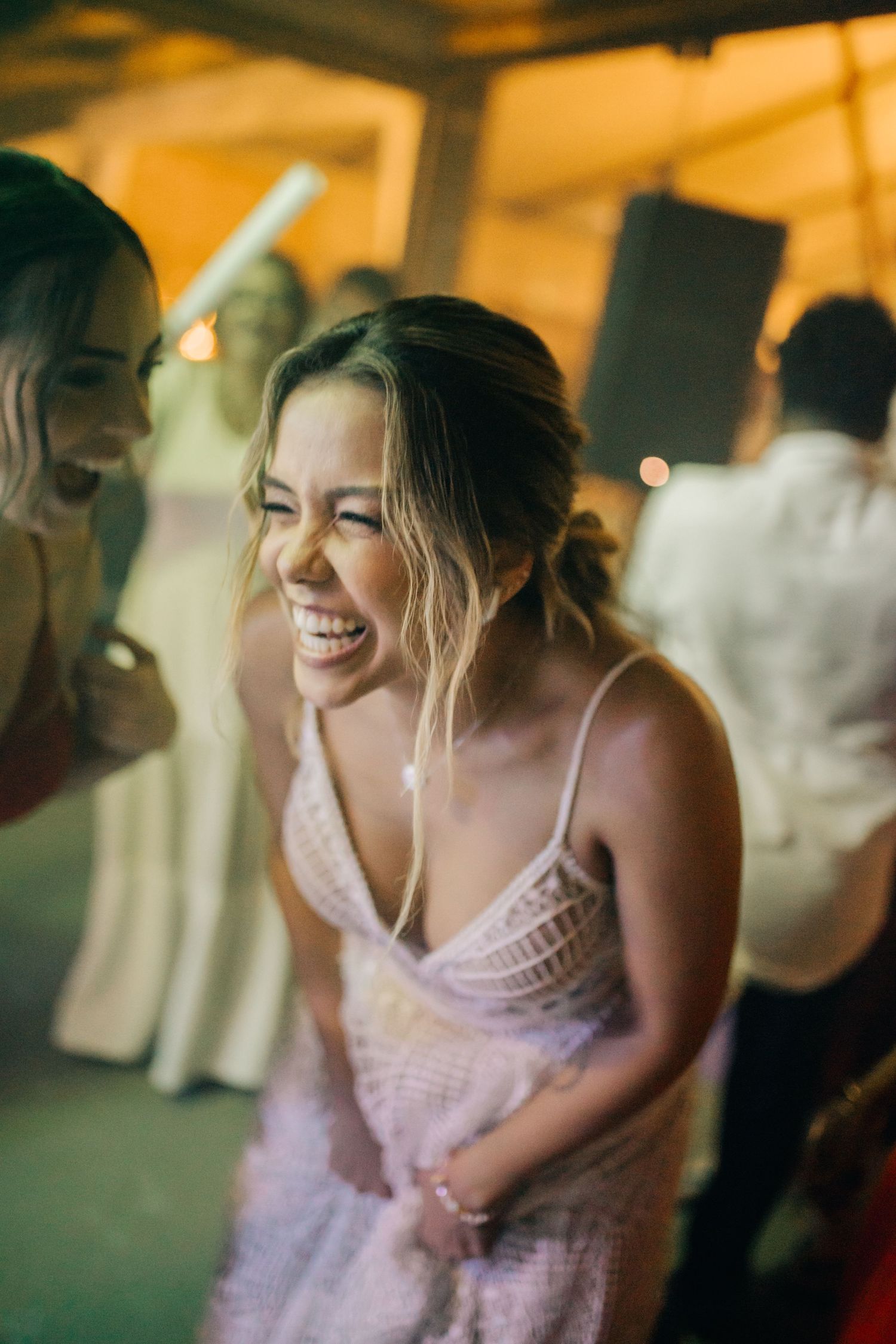 Guests share a joyful moment at an indoor celebration wearing evening attire.