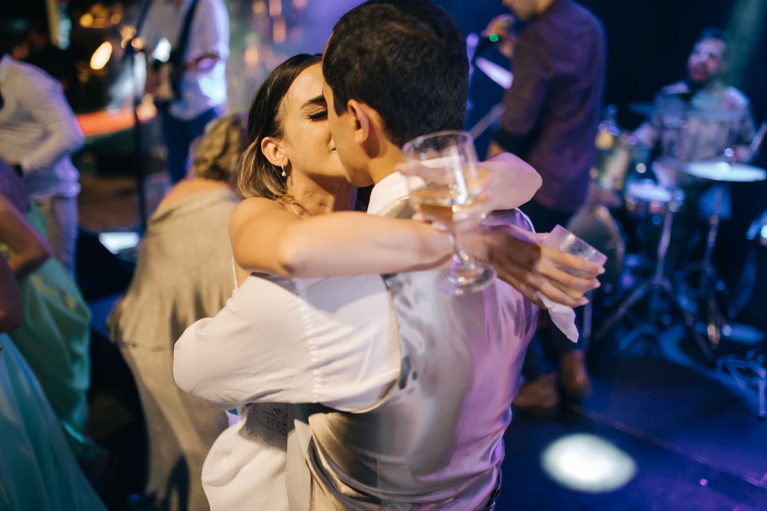 Couples slow dancing together under atmospheric blue lighting at an elegant event.