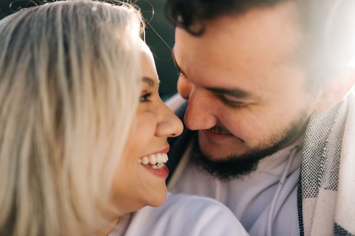 Close up shot of a romantic couple gazing at each other against a bright background.
