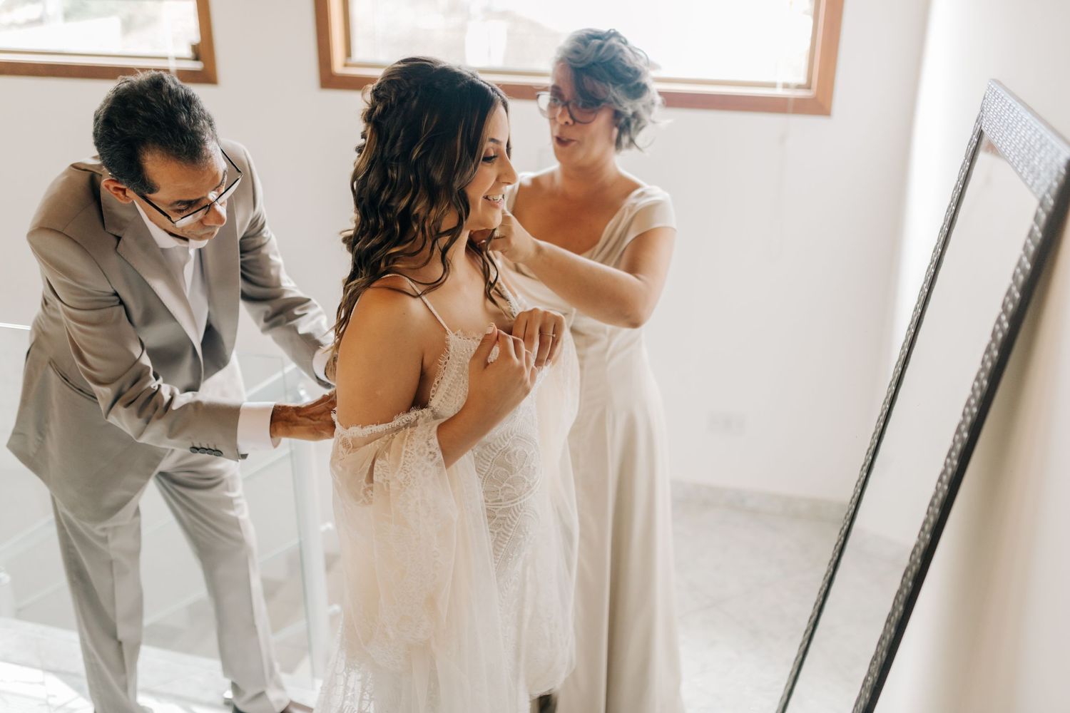 Getting ready moment in bright room with wedding dress preparations.